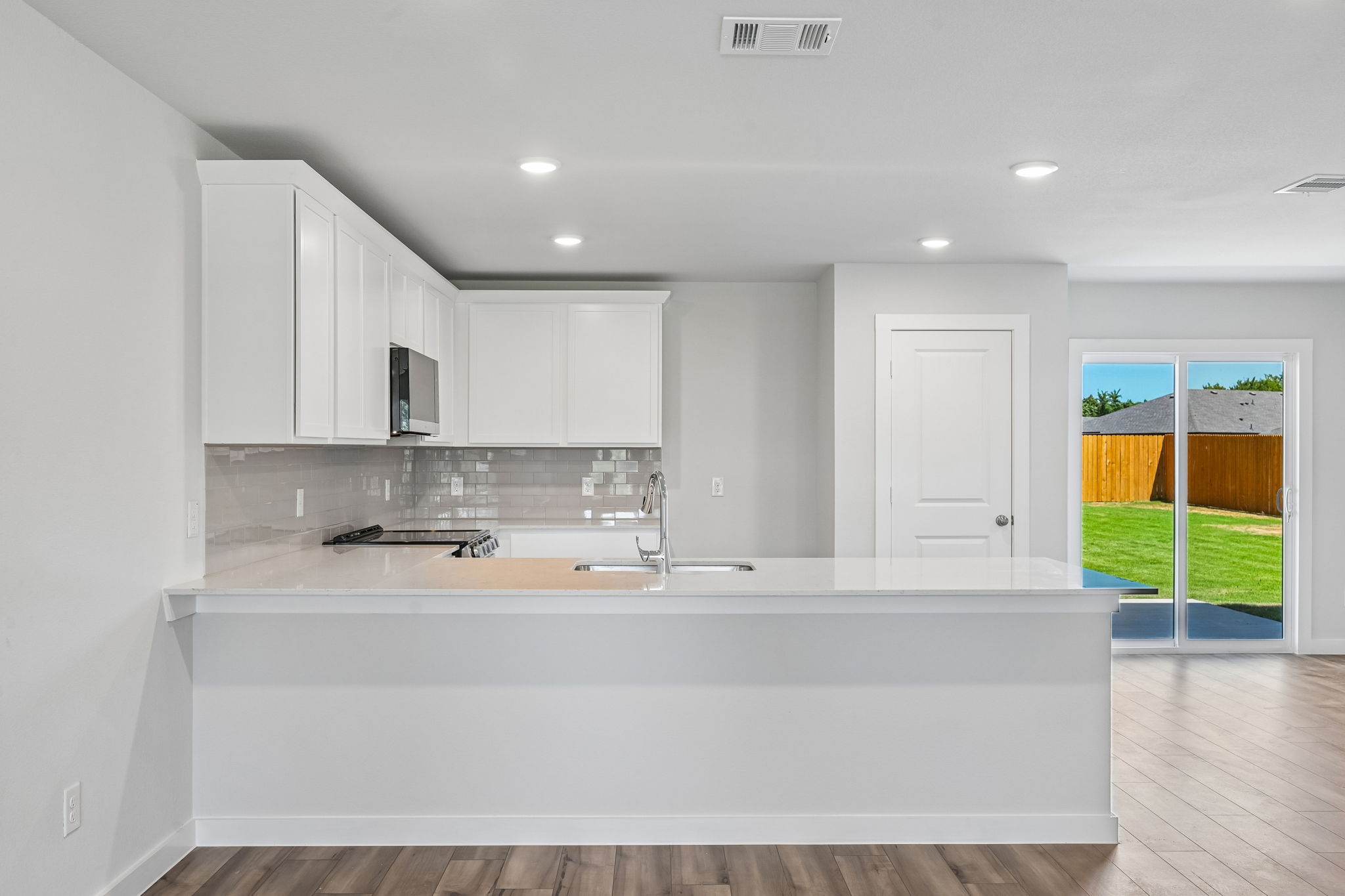 A kitchen with white cabinets.