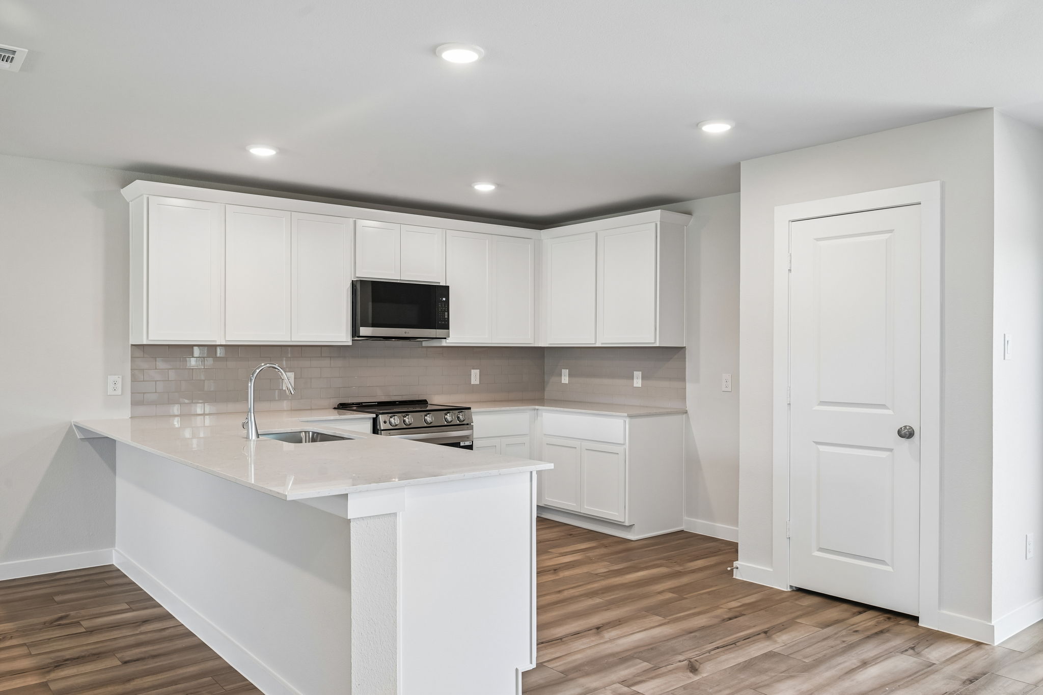 A kitchen with white cabinets.