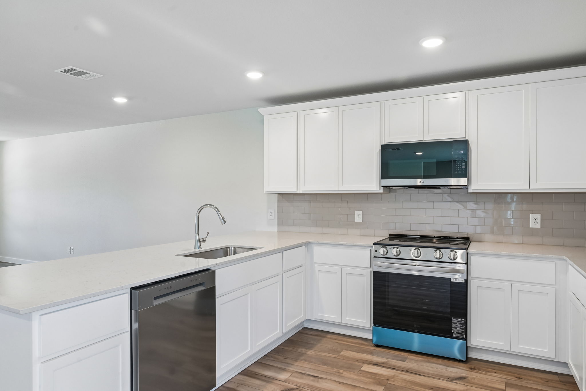 A kitchen with white cabinets.