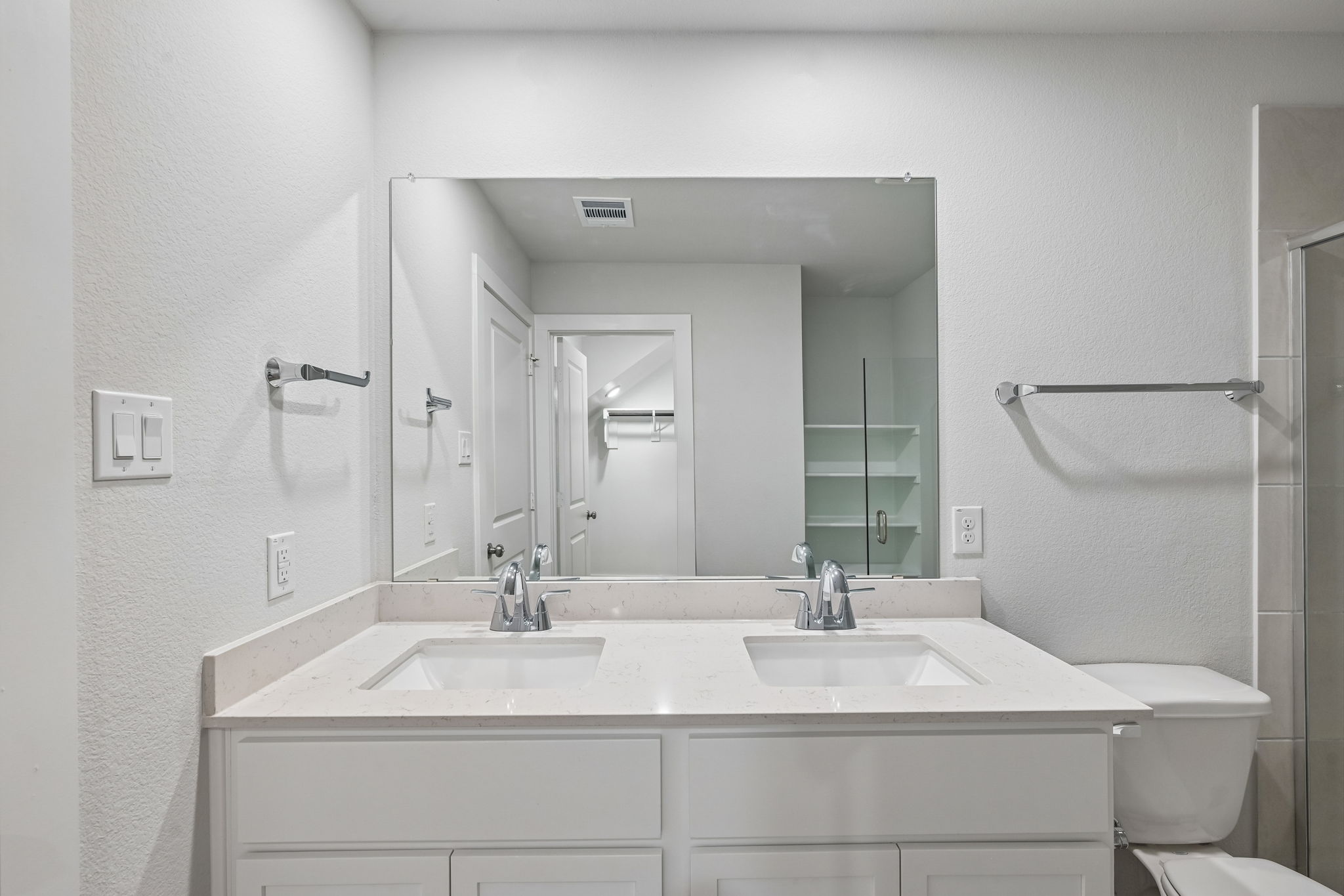 A bathroom with a large mirror.