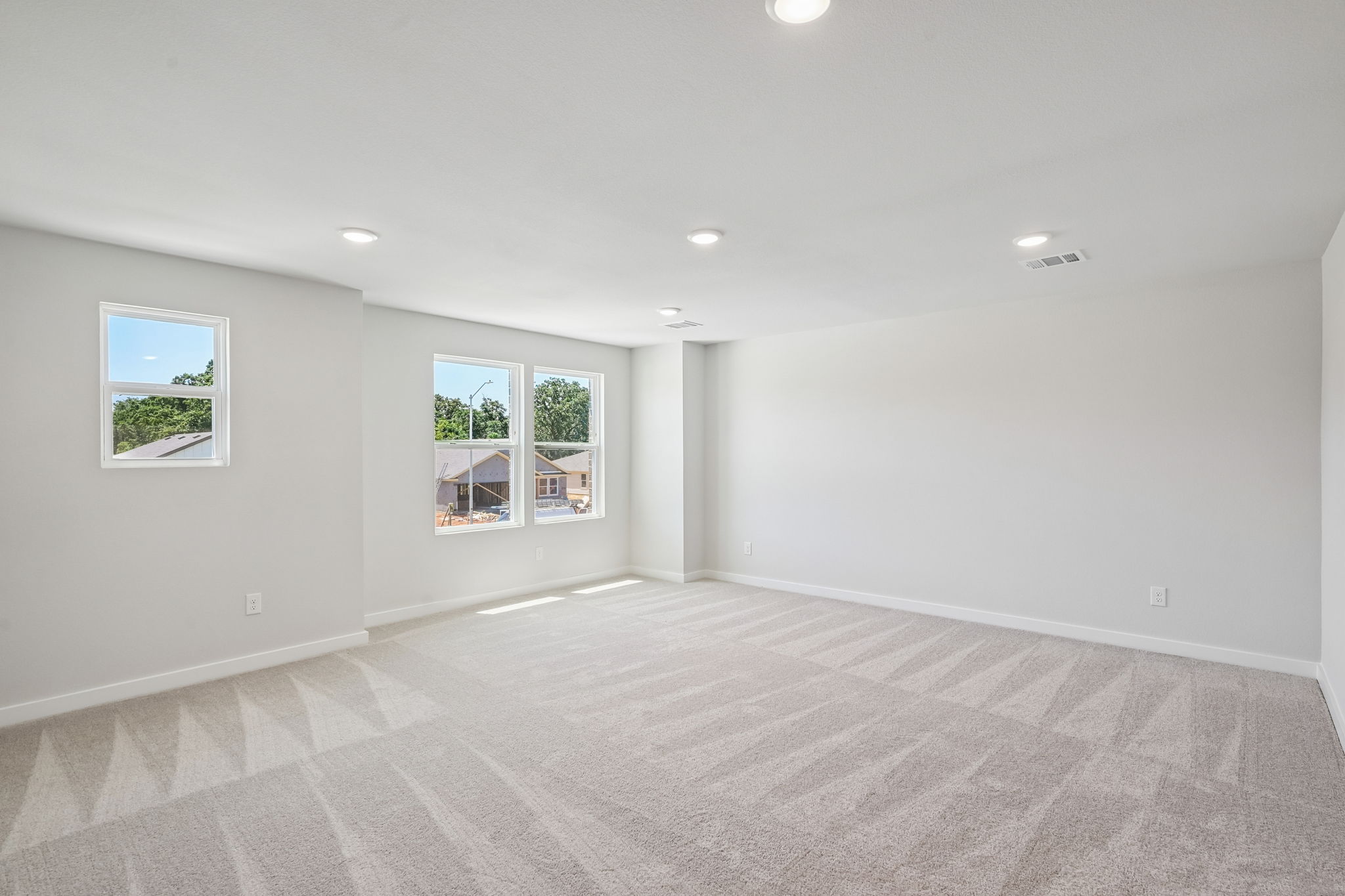 A room with windows and a carpet.