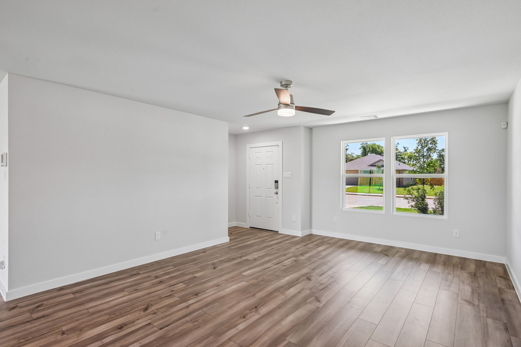 A room with a wood floor and a wood floor with a window.
