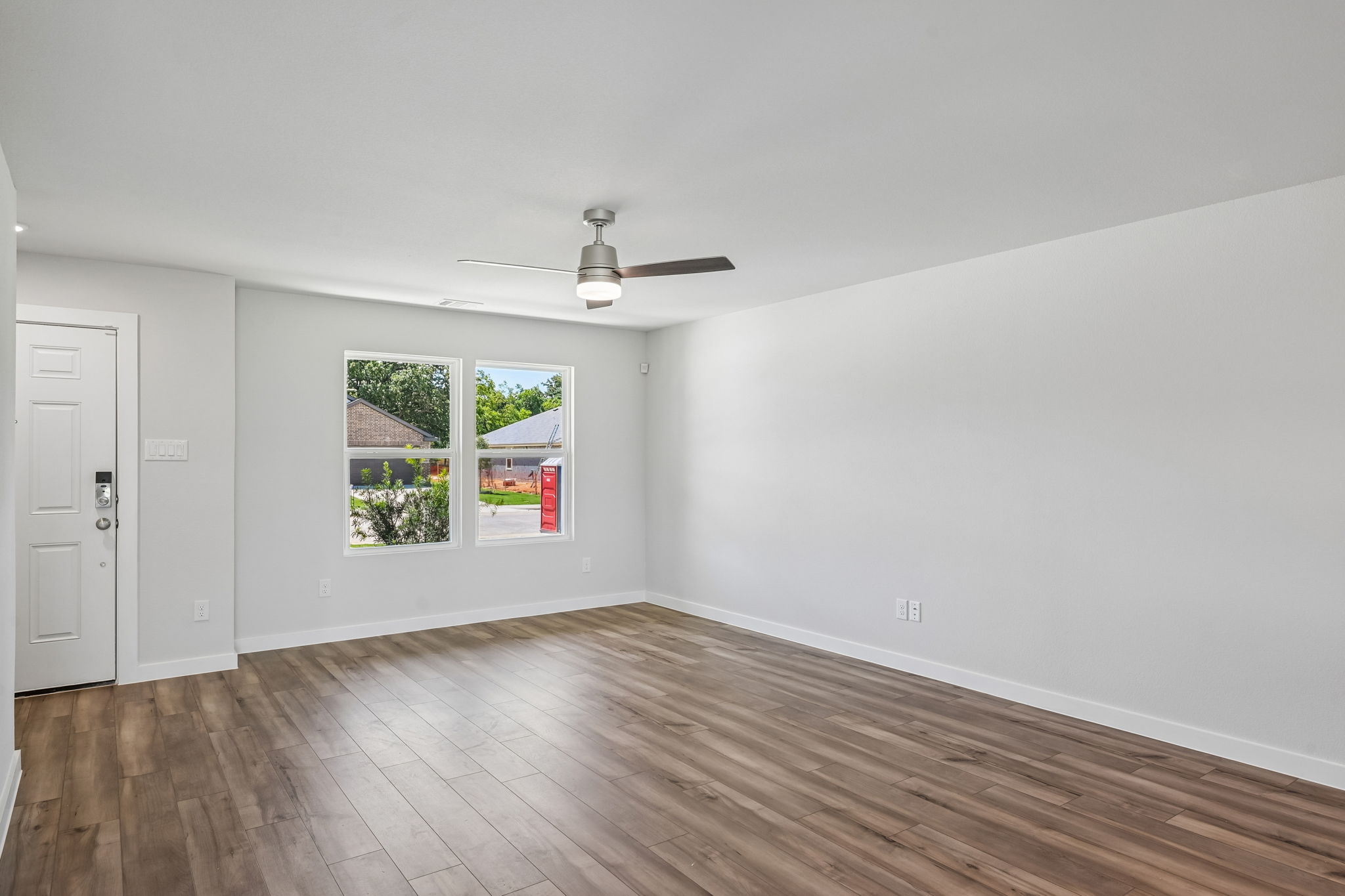 A room with a wood floor and a ceiling fan and a wood floor.