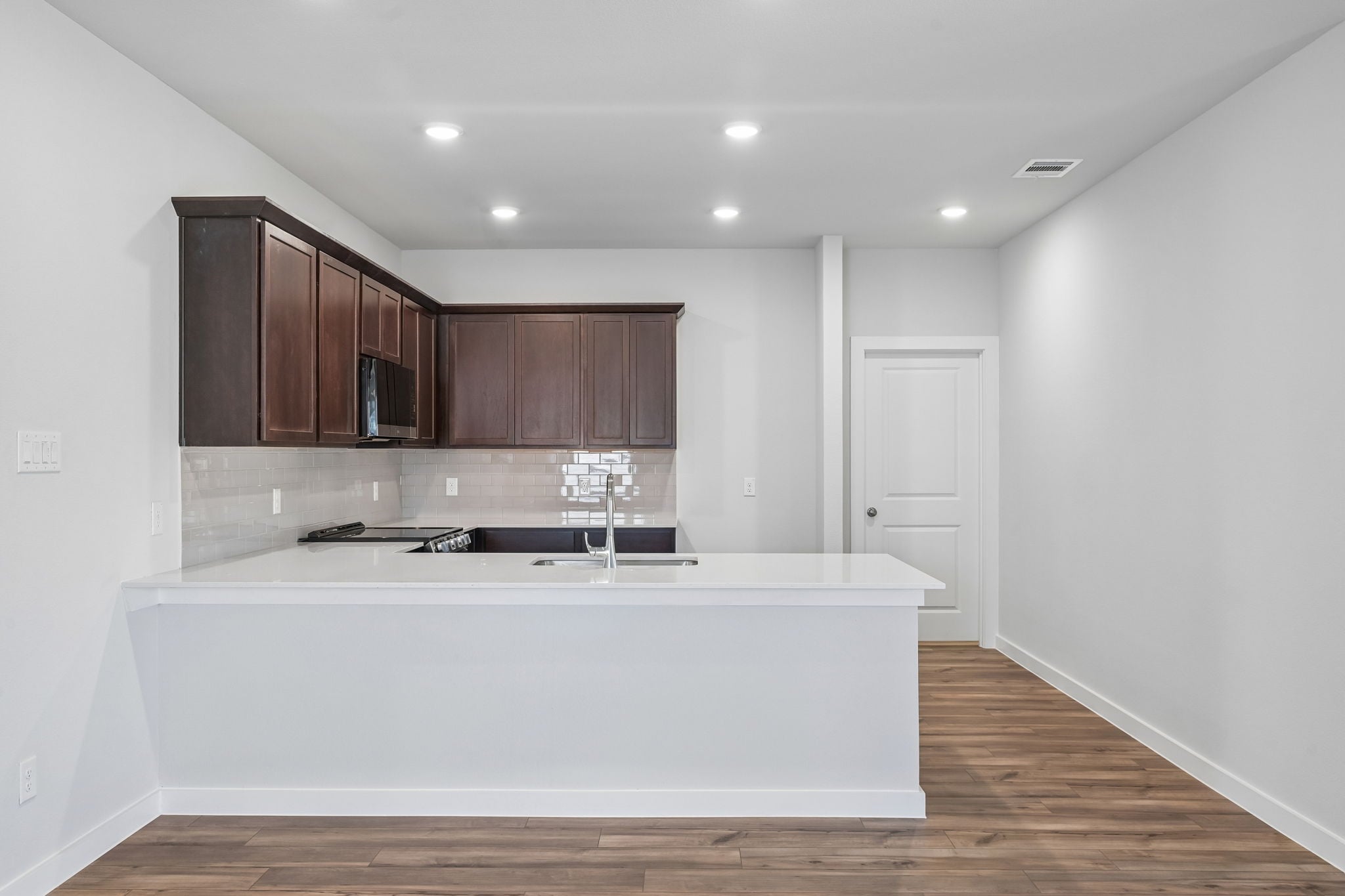 A kitchen with white cabinets.