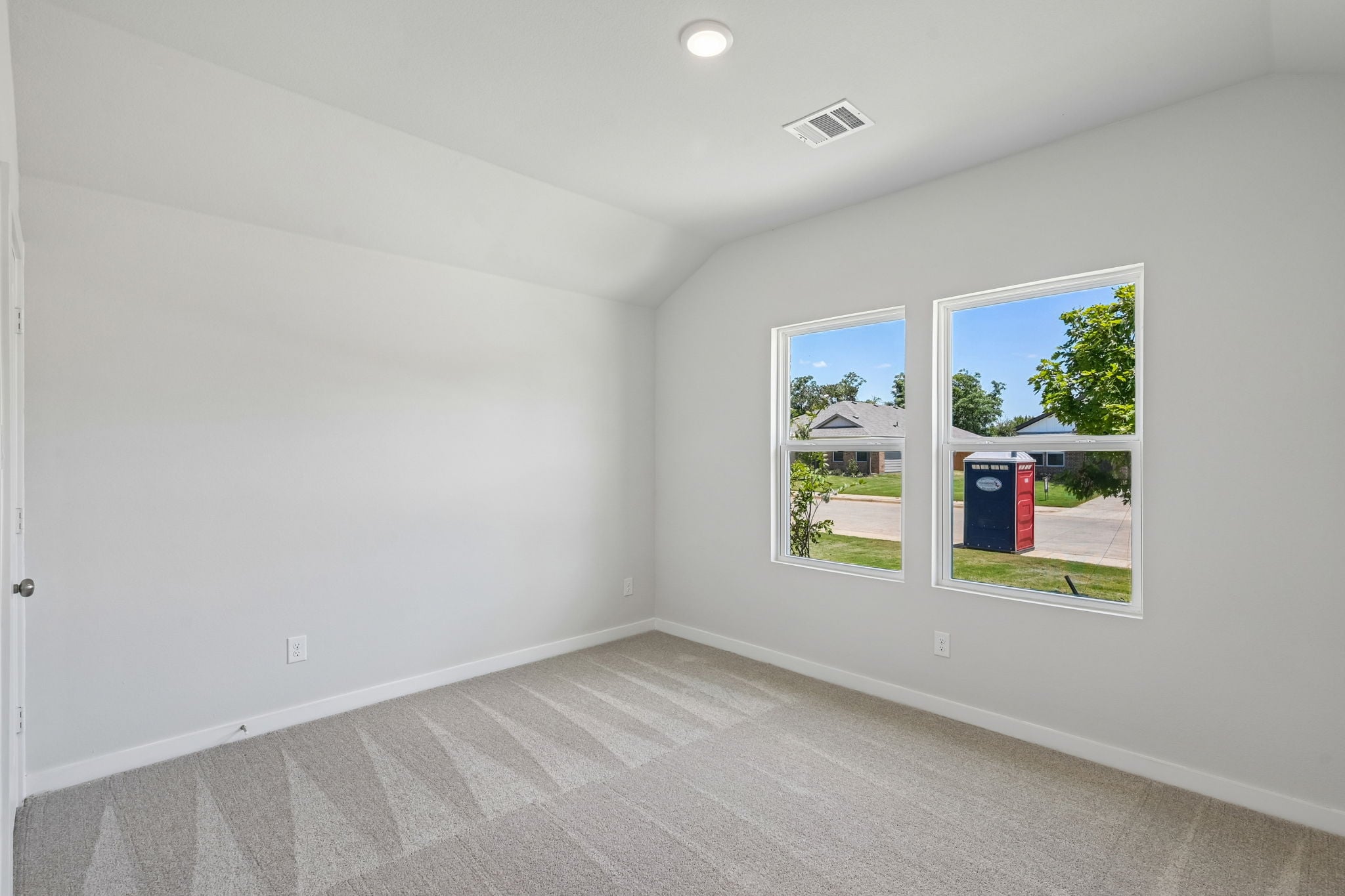 A room with a window and a rug.