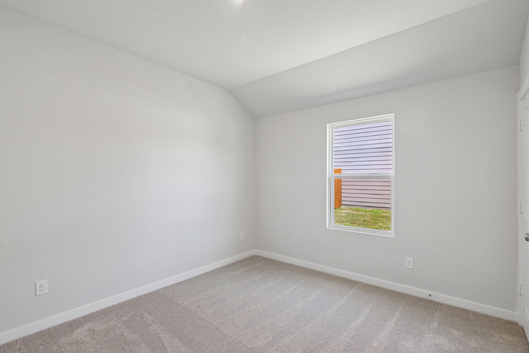 A room with a window and a carpet.