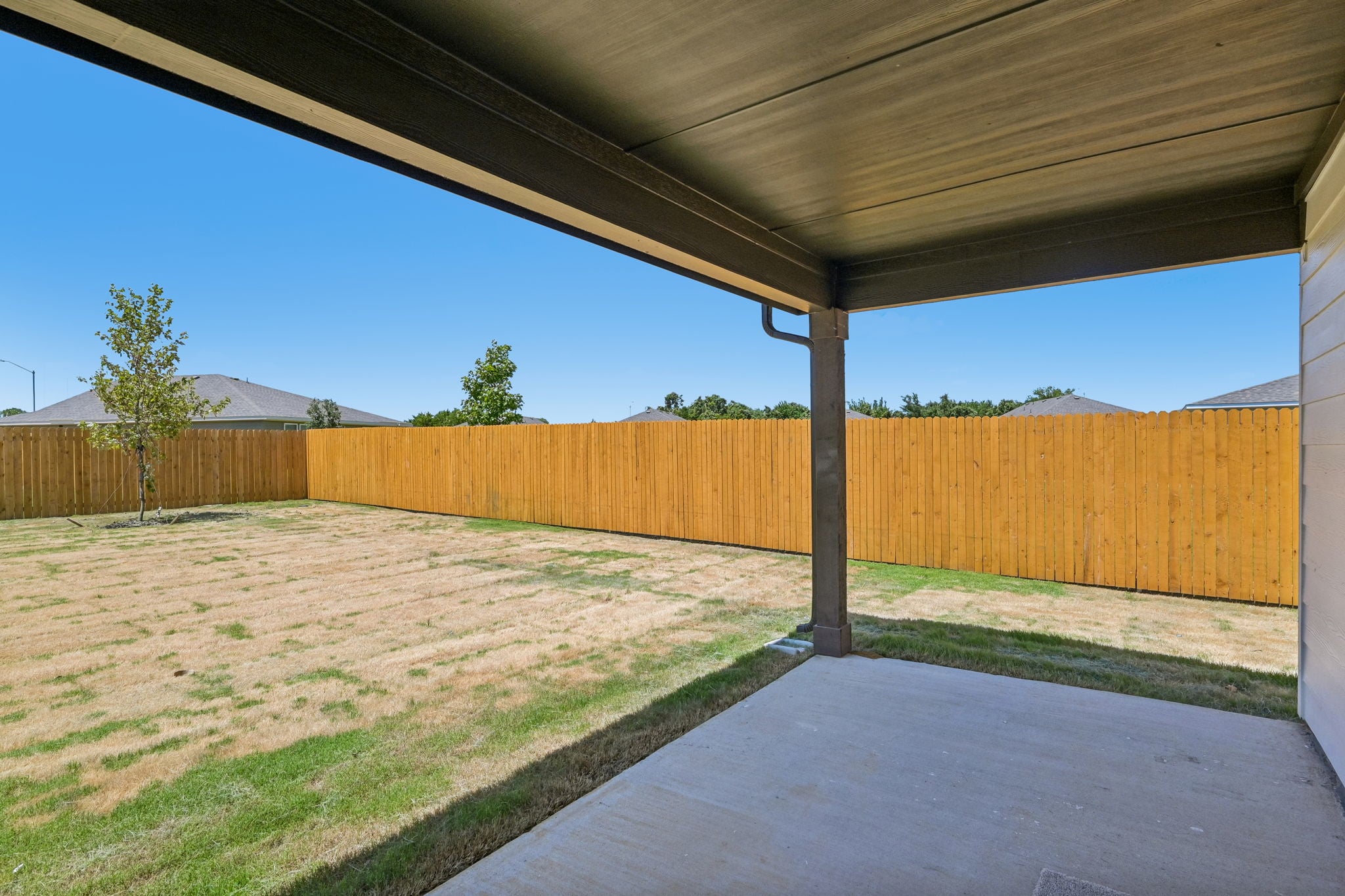 A fenced in area with a wood fence and a tree.