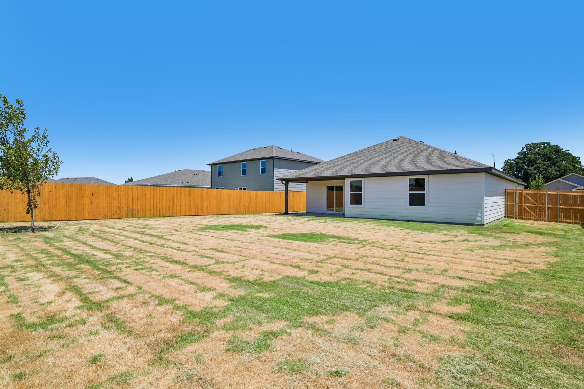 A fenced in yard with a house in the background.