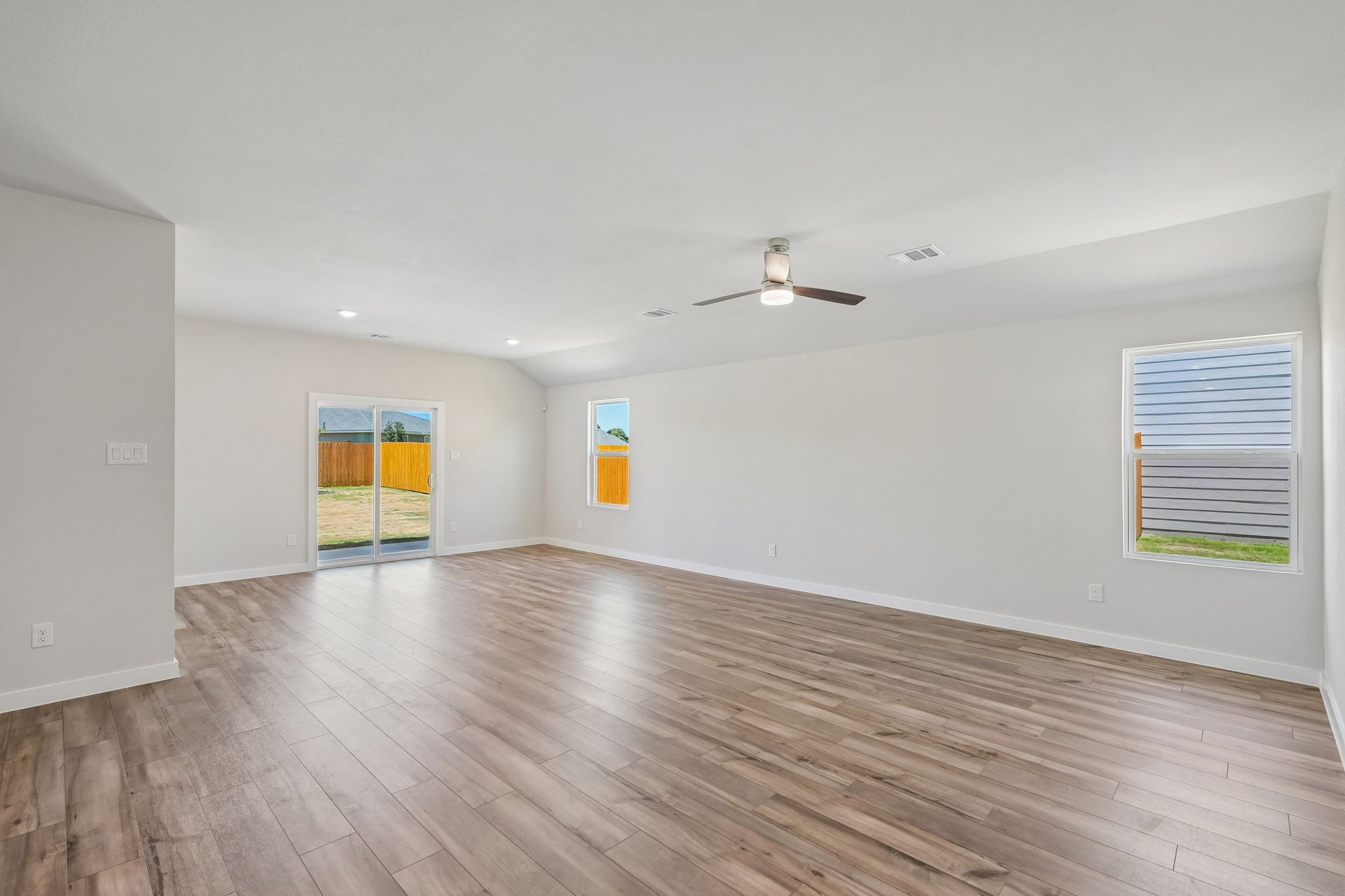 A room with a wood floor and a ceiling fan.