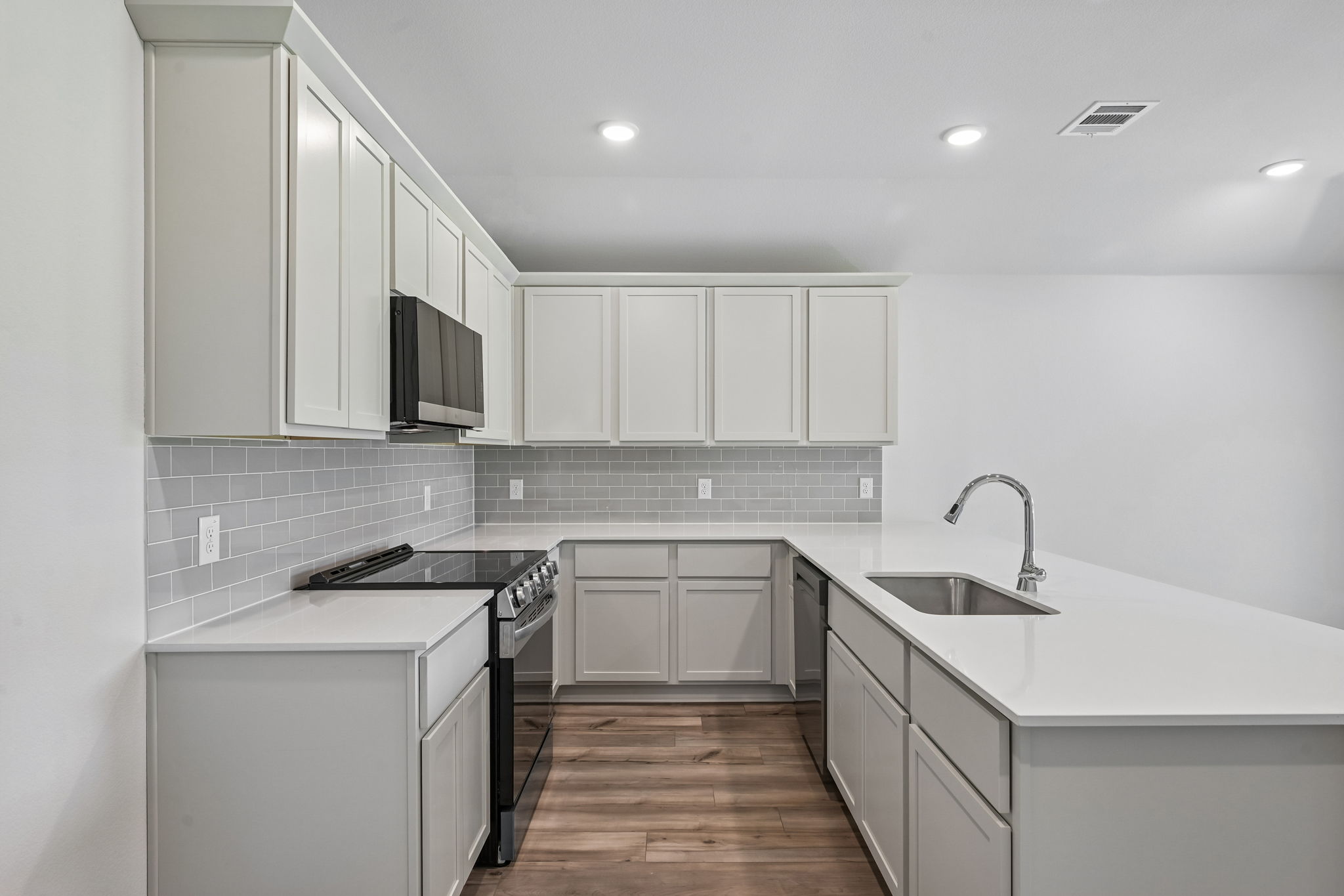 A kitchen with white cabinets.