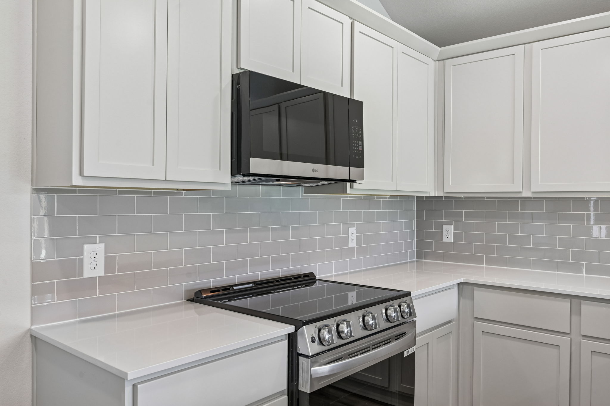 A kitchen with white cabinets.