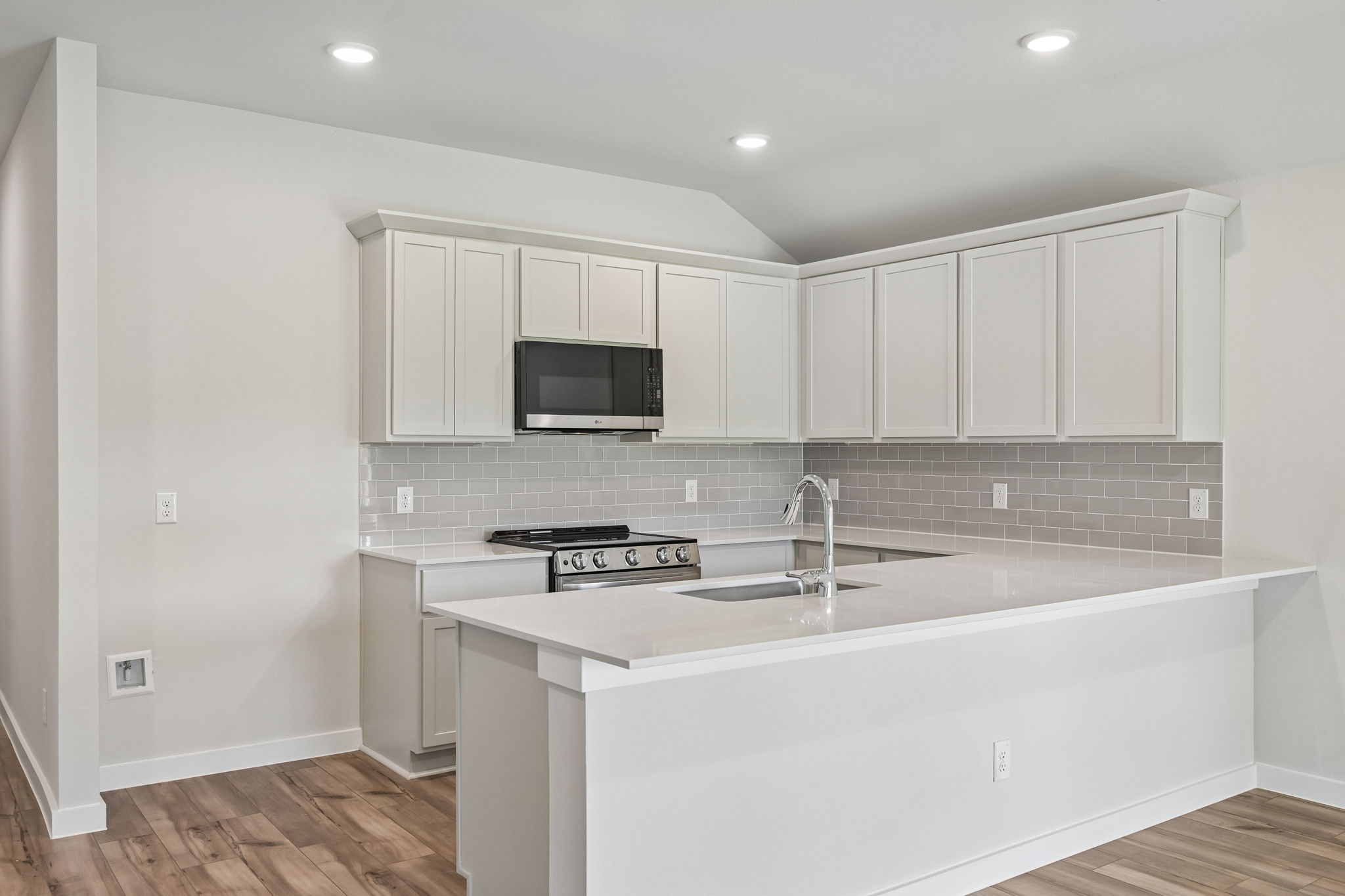 A kitchen with white cabinets.