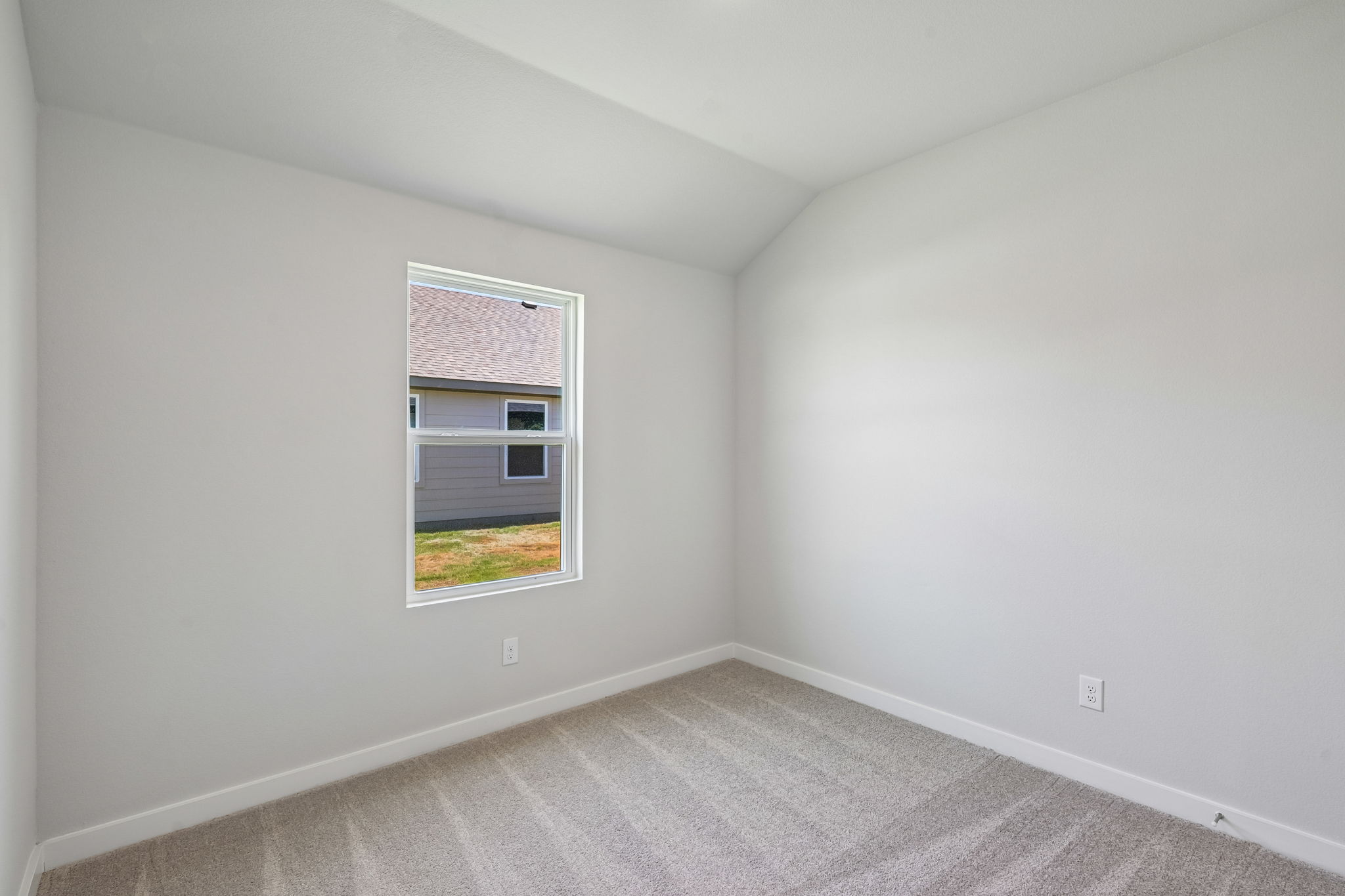 A room with a window and a carpet.
