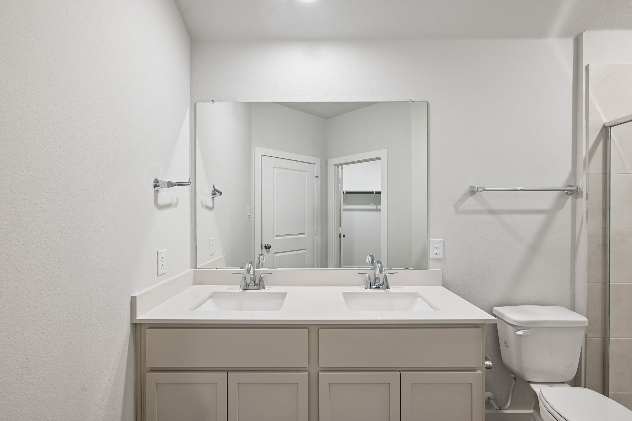 A bathroom with a sink toilet and mirror.