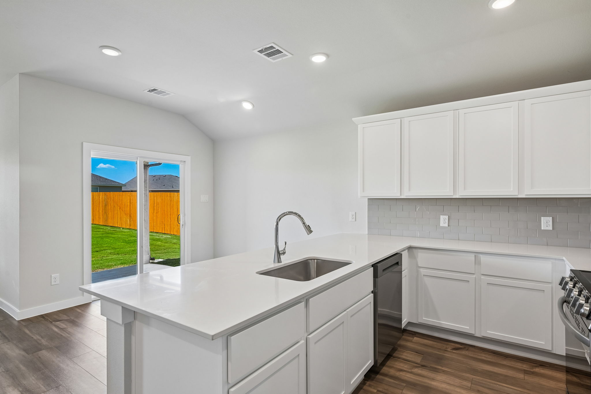 A kitchen with white cabinets.