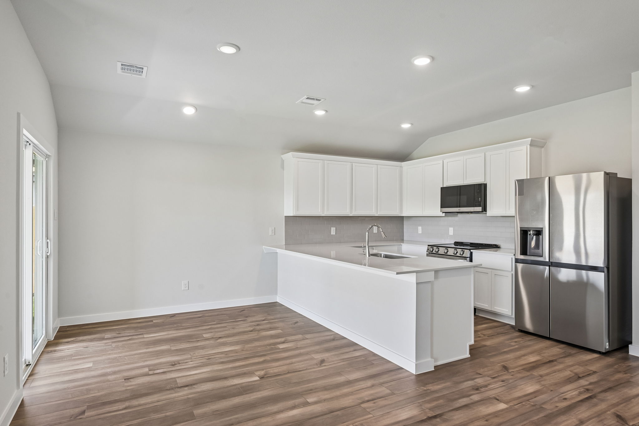 A kitchen with white cabinets.
