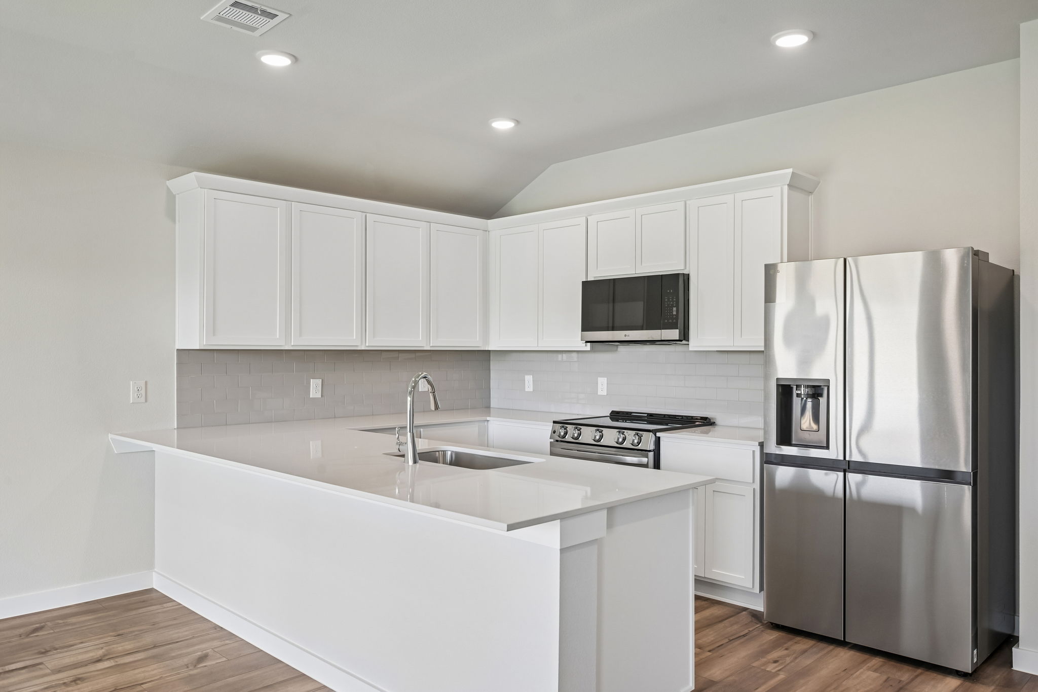 A kitchen with white cabinets.