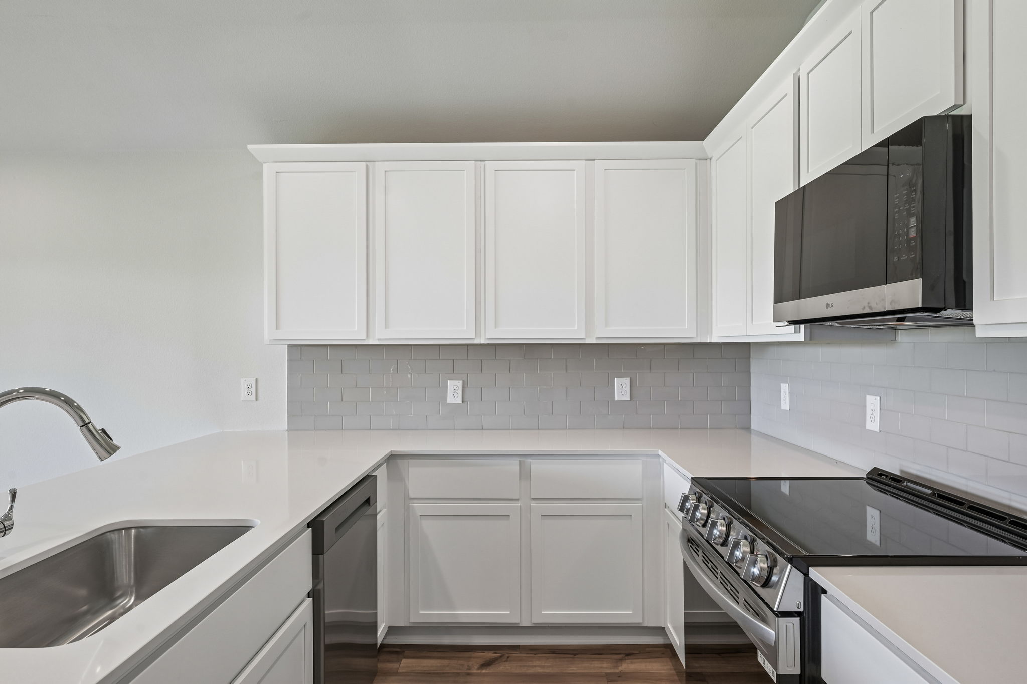 A kitchen with white cabinets.