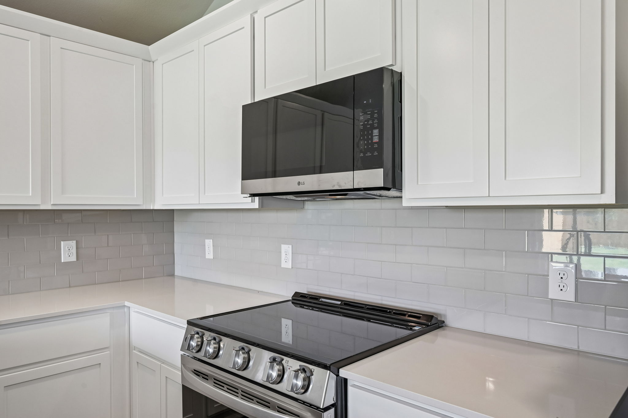 A kitchen with white cabinets.