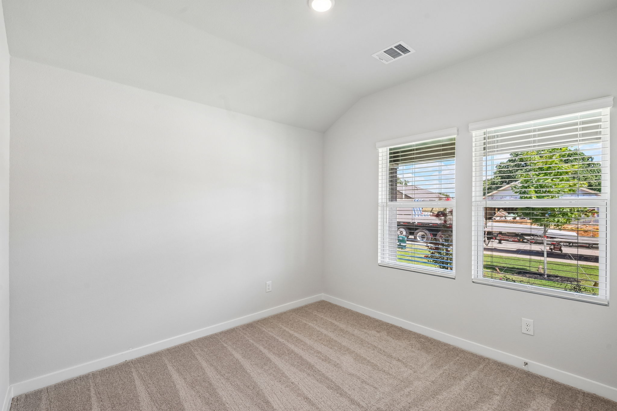 A room with a window and a wood floor.