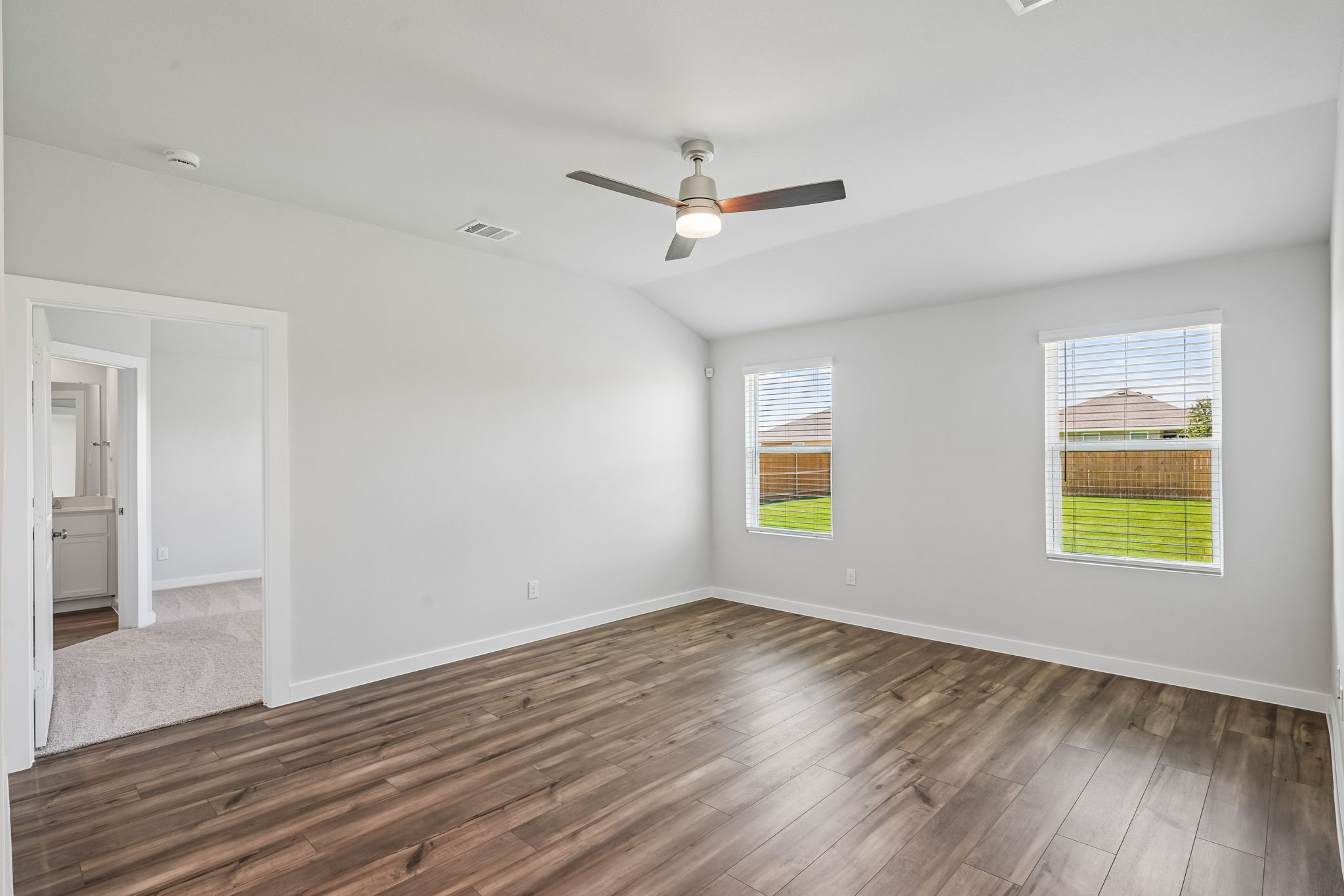 A room with a wood floor and a ceiling fan.
