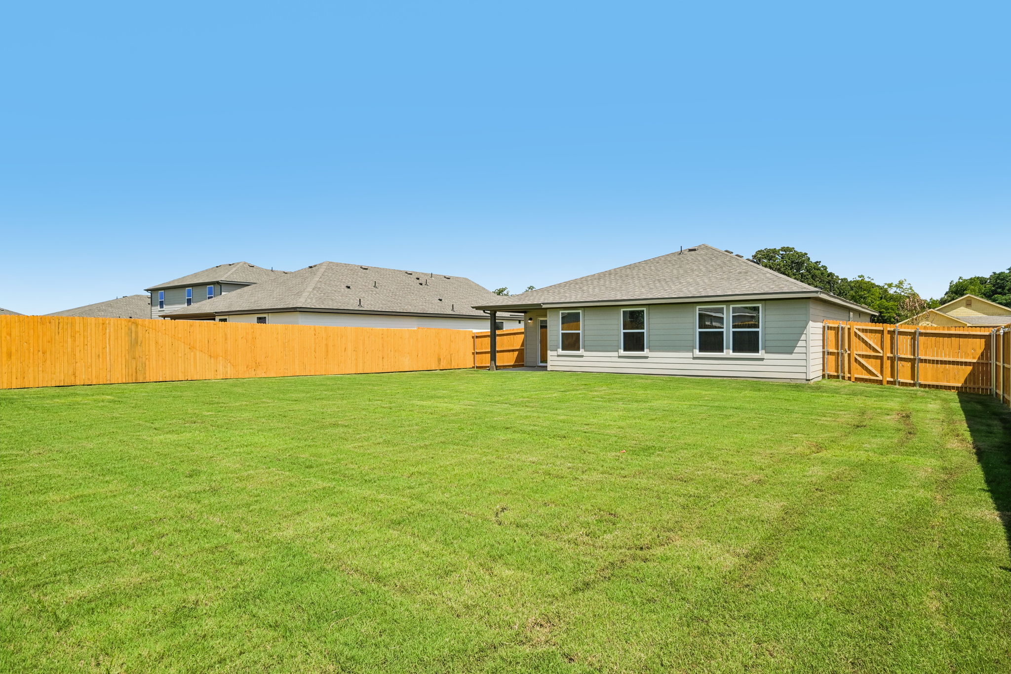 A house with a fence and grass.