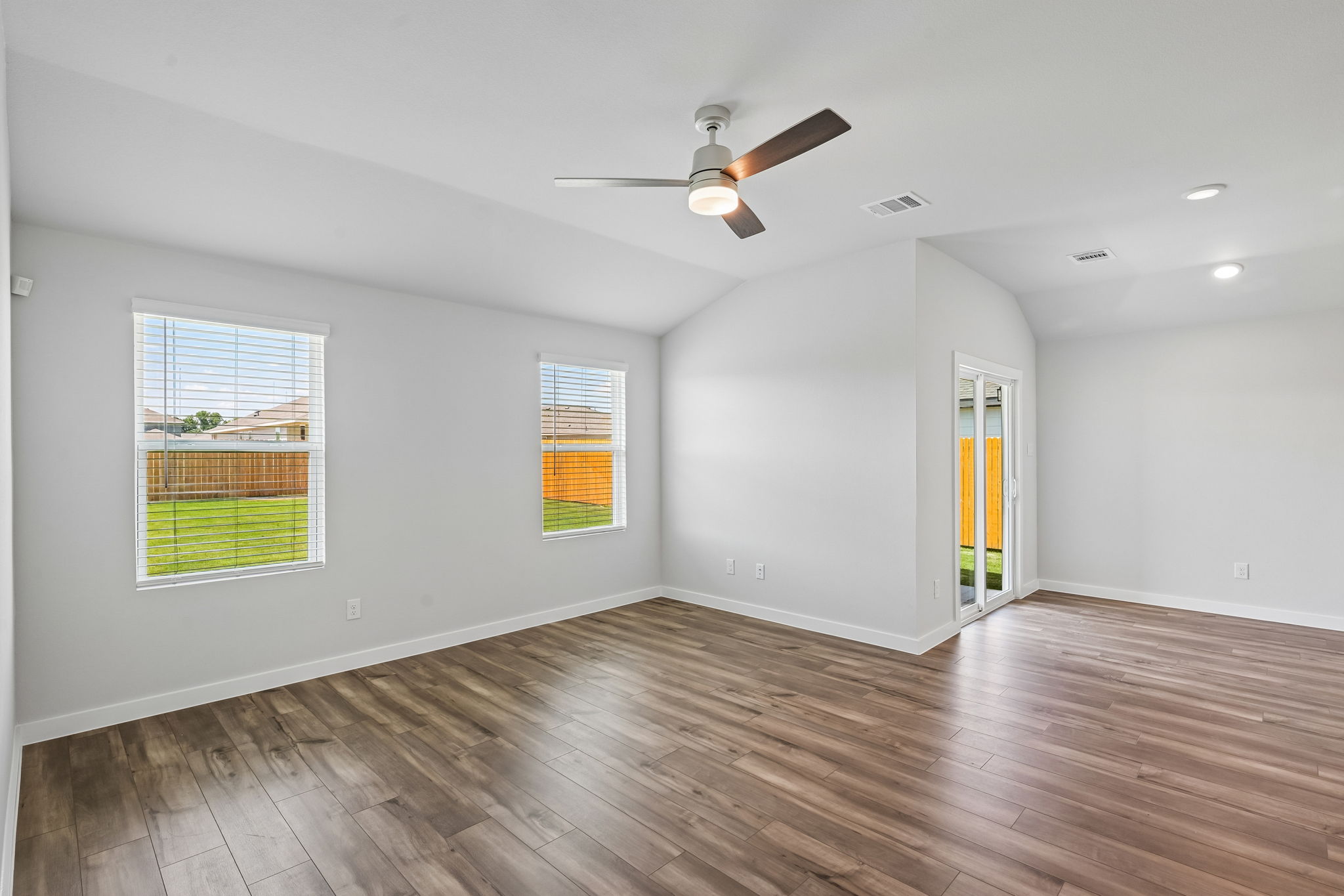 A room with a wood floor and a ceiling fan.