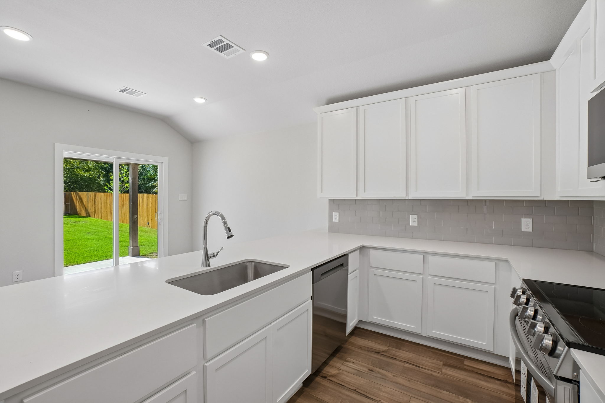 A kitchen with white cabinets.