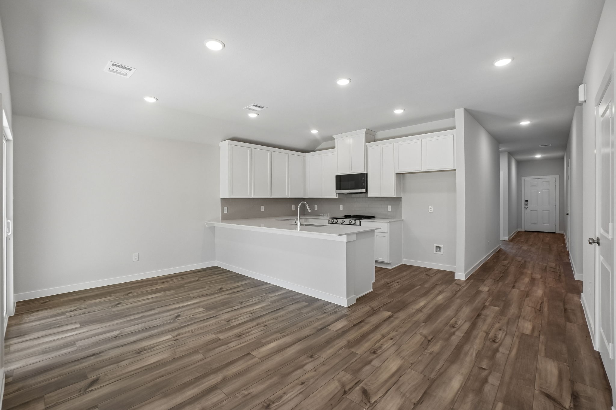 A kitchen with white cabinets.