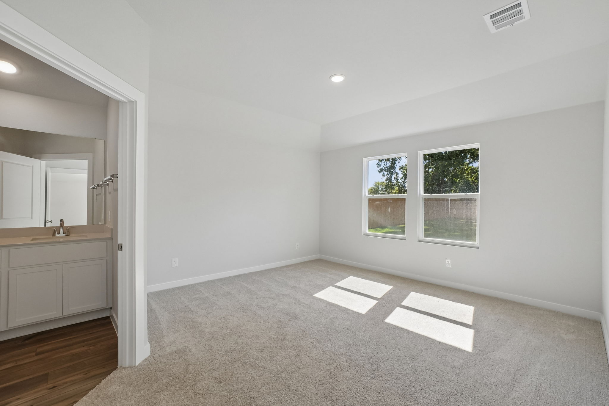 A room with a rug and a window.