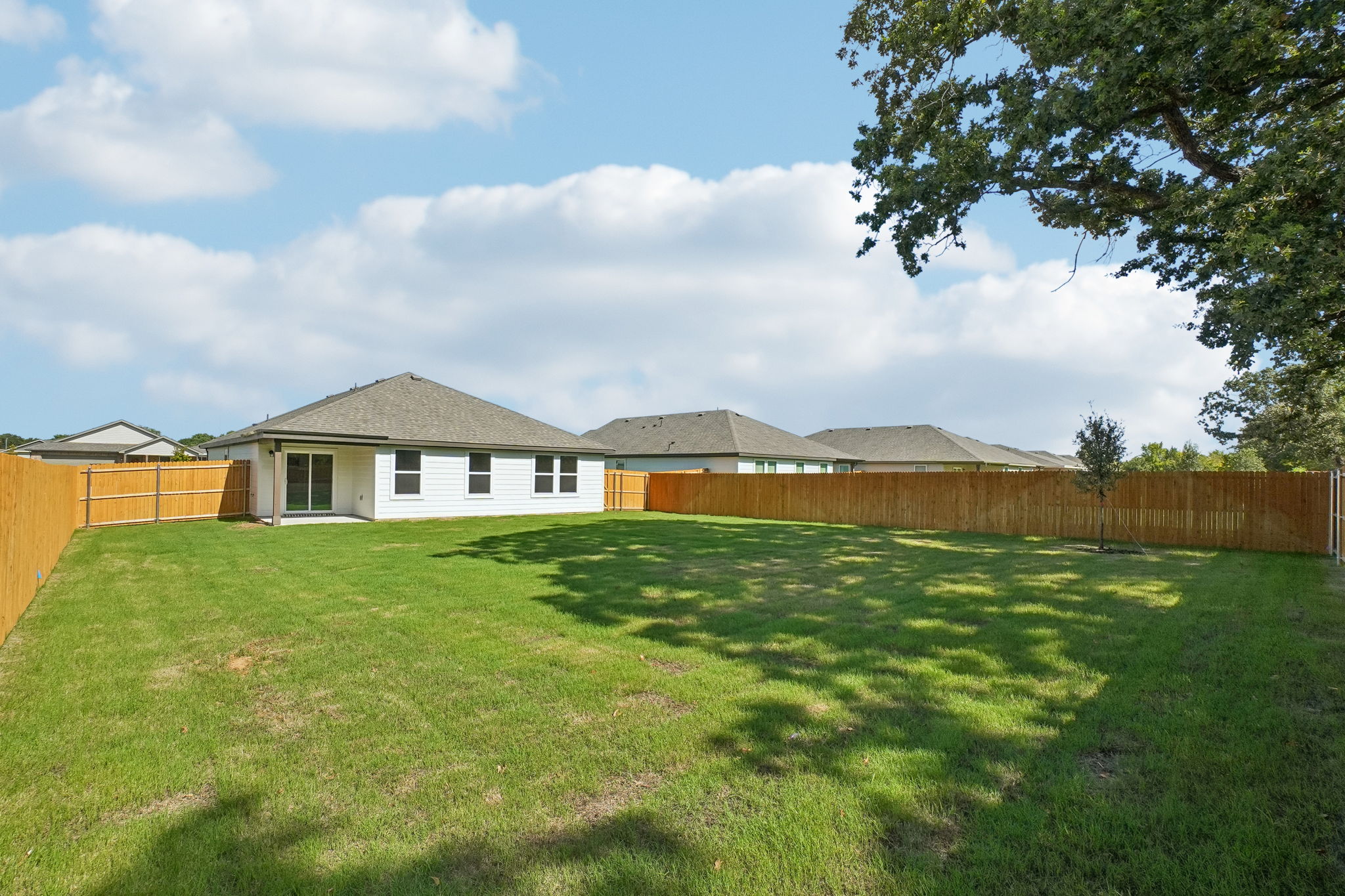 A fenced in yard with a house in the background.