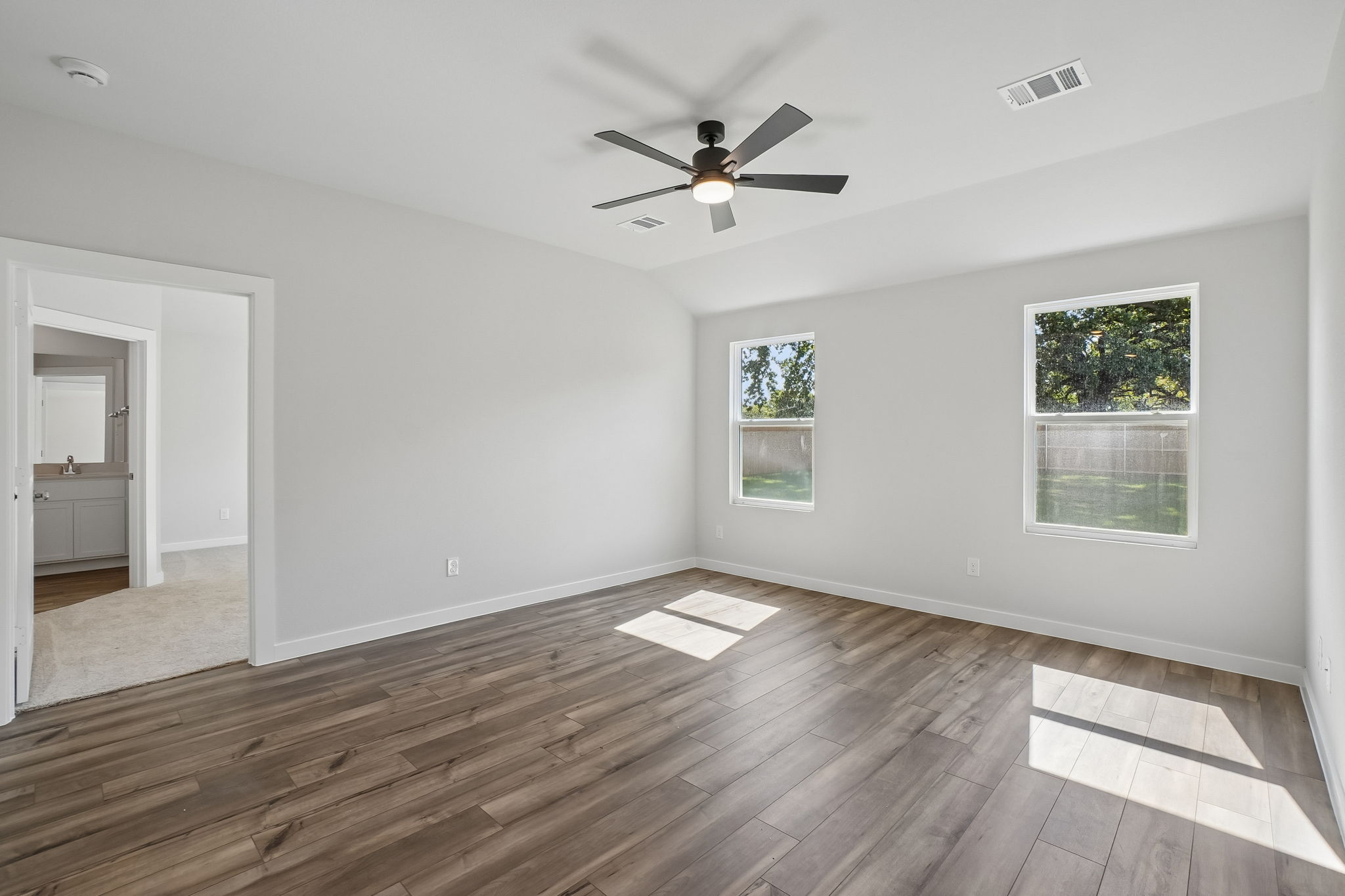 A room with a wood floor and a ceiling fan.
