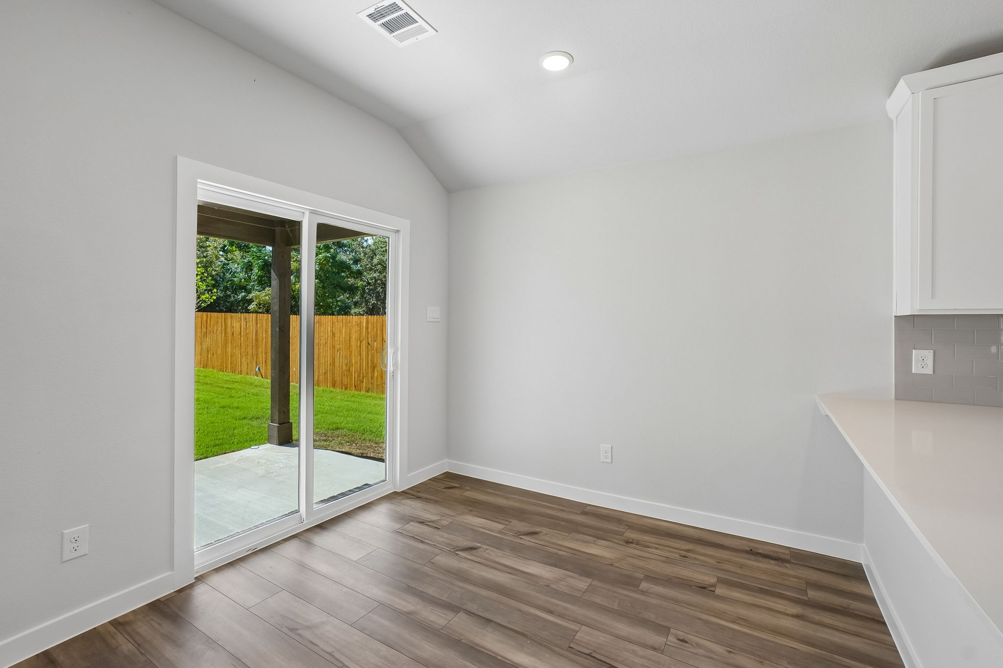 A room with a wood floor and a wood floor with a door.