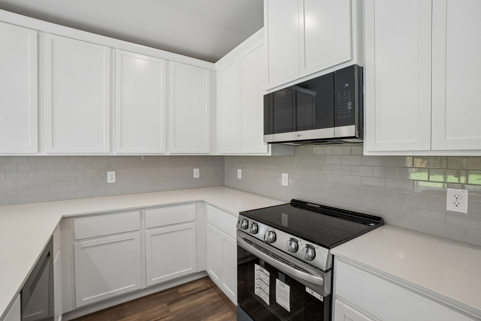 A kitchen with white cabinets.