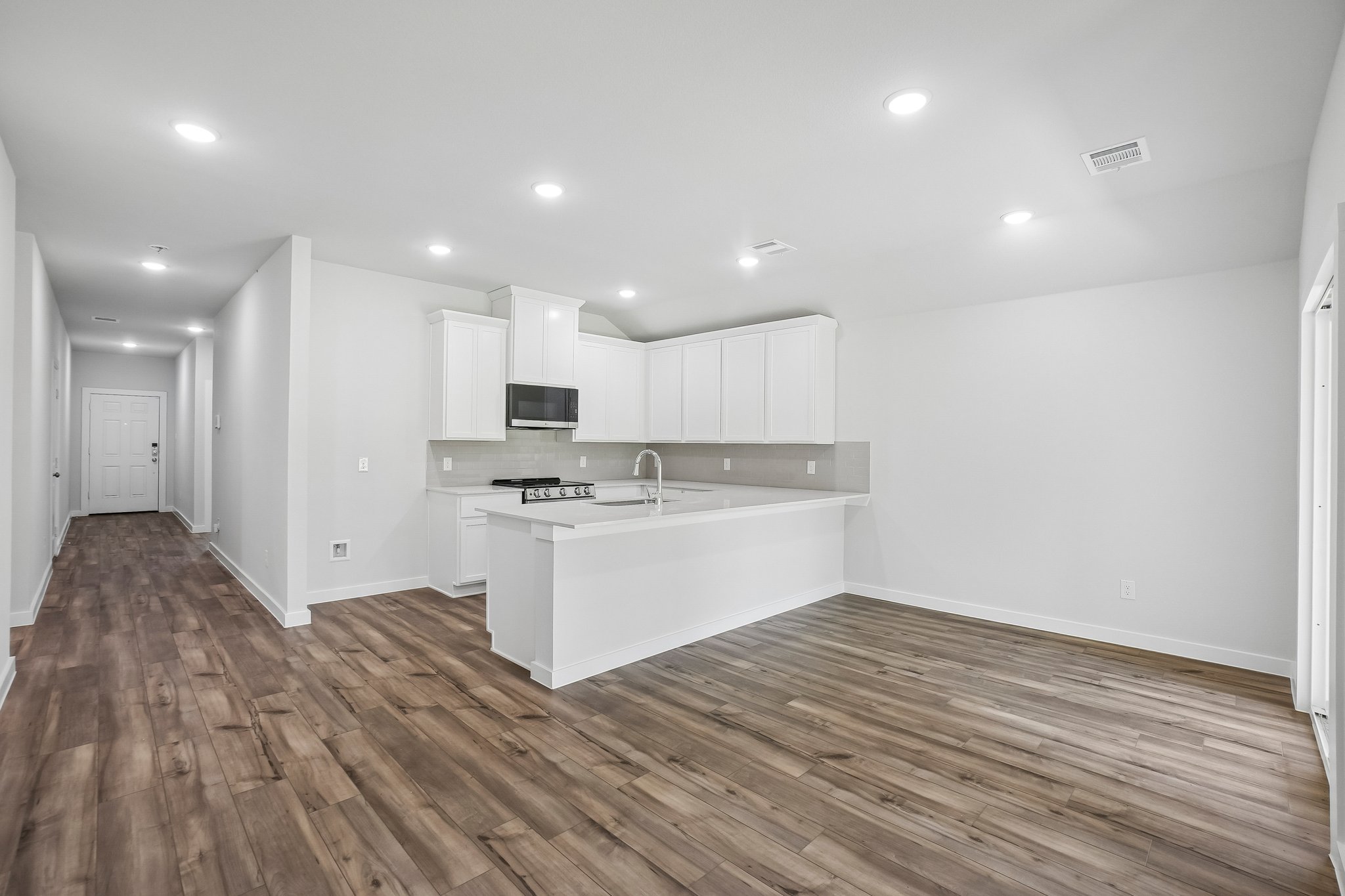 A kitchen with white cabinets.