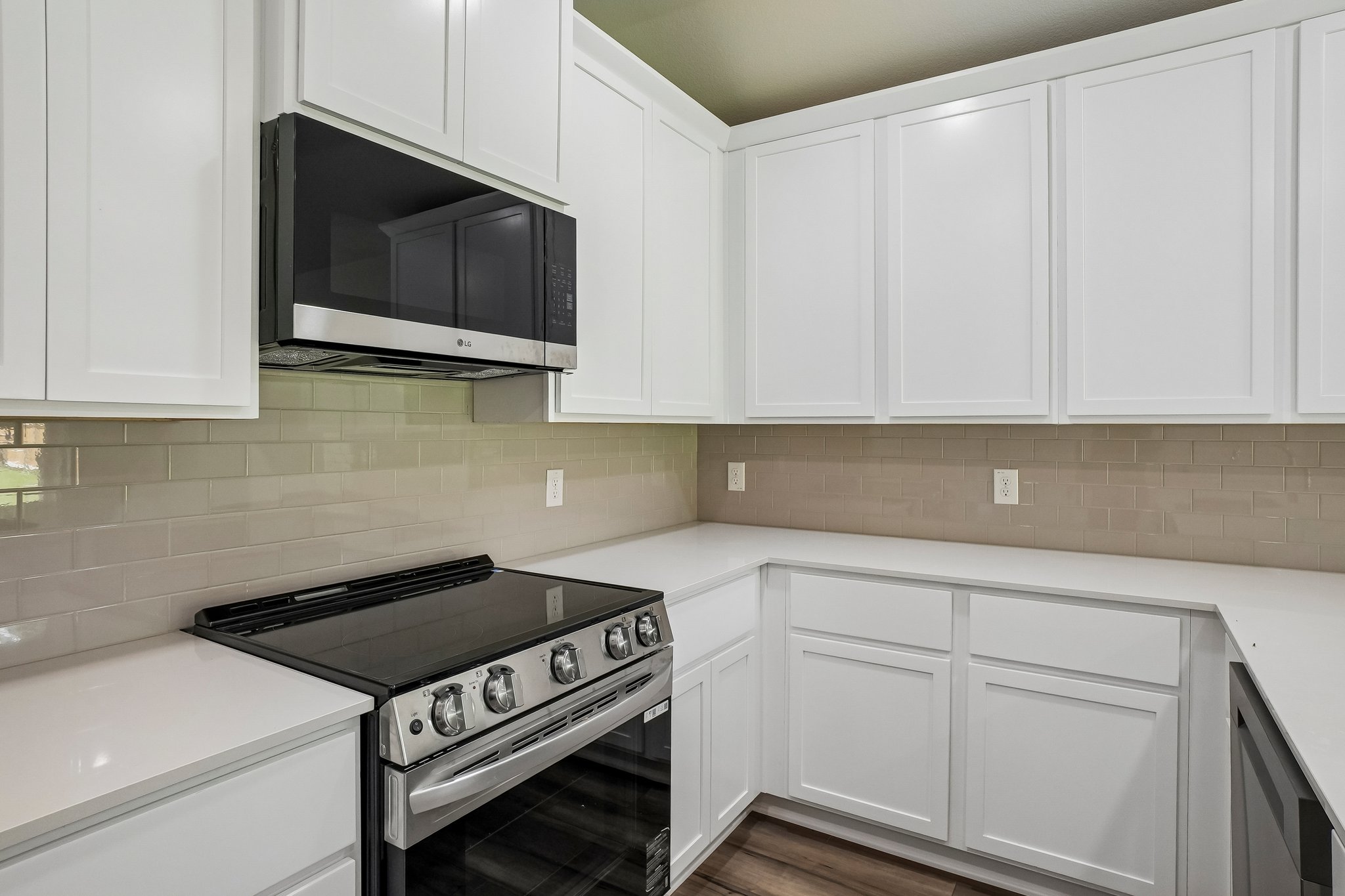 A kitchen with white cabinets.