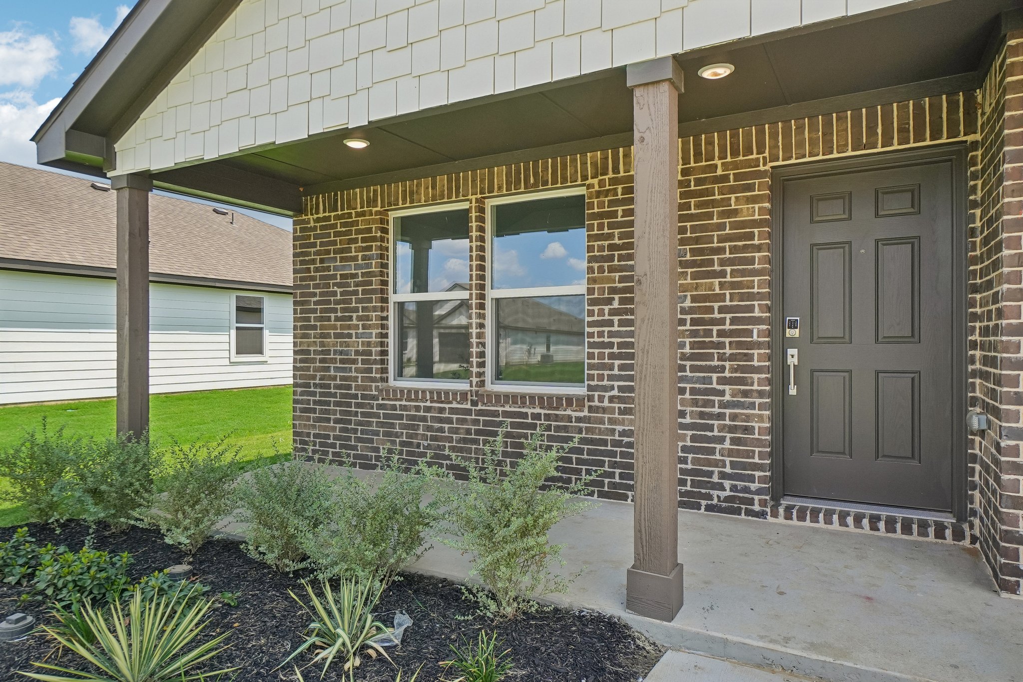 A house with a brick front and a door.