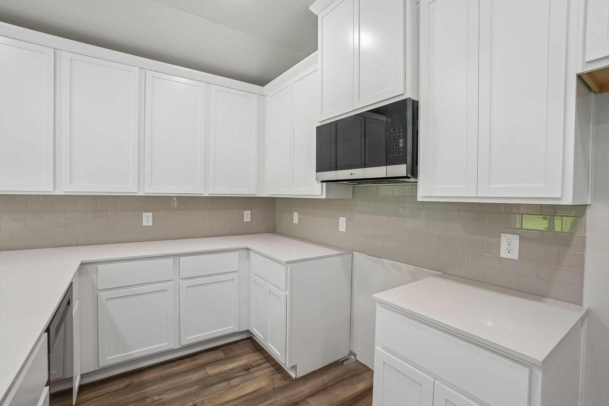A kitchen with white cabinets.