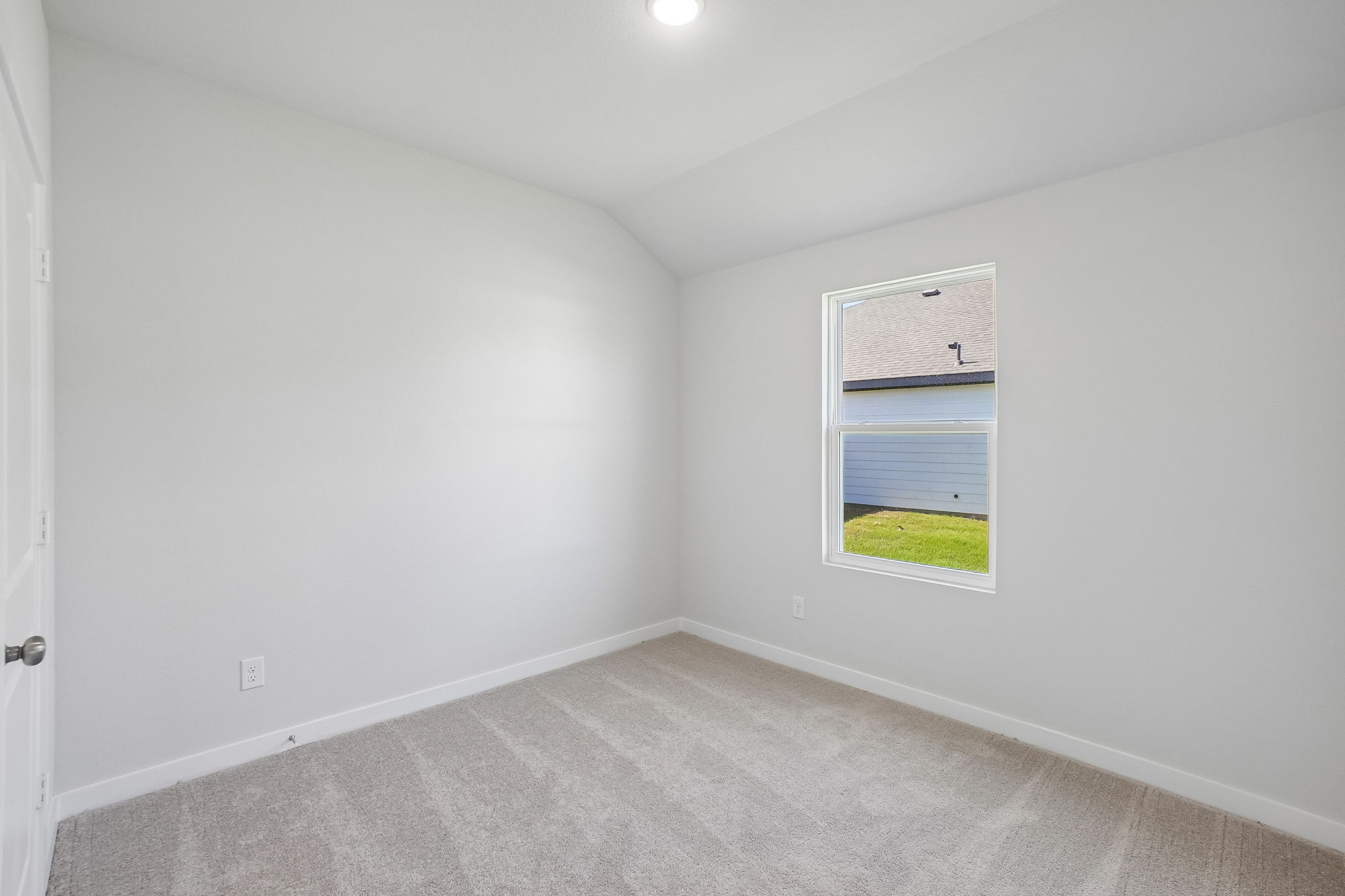 A room with a window and a carpet.