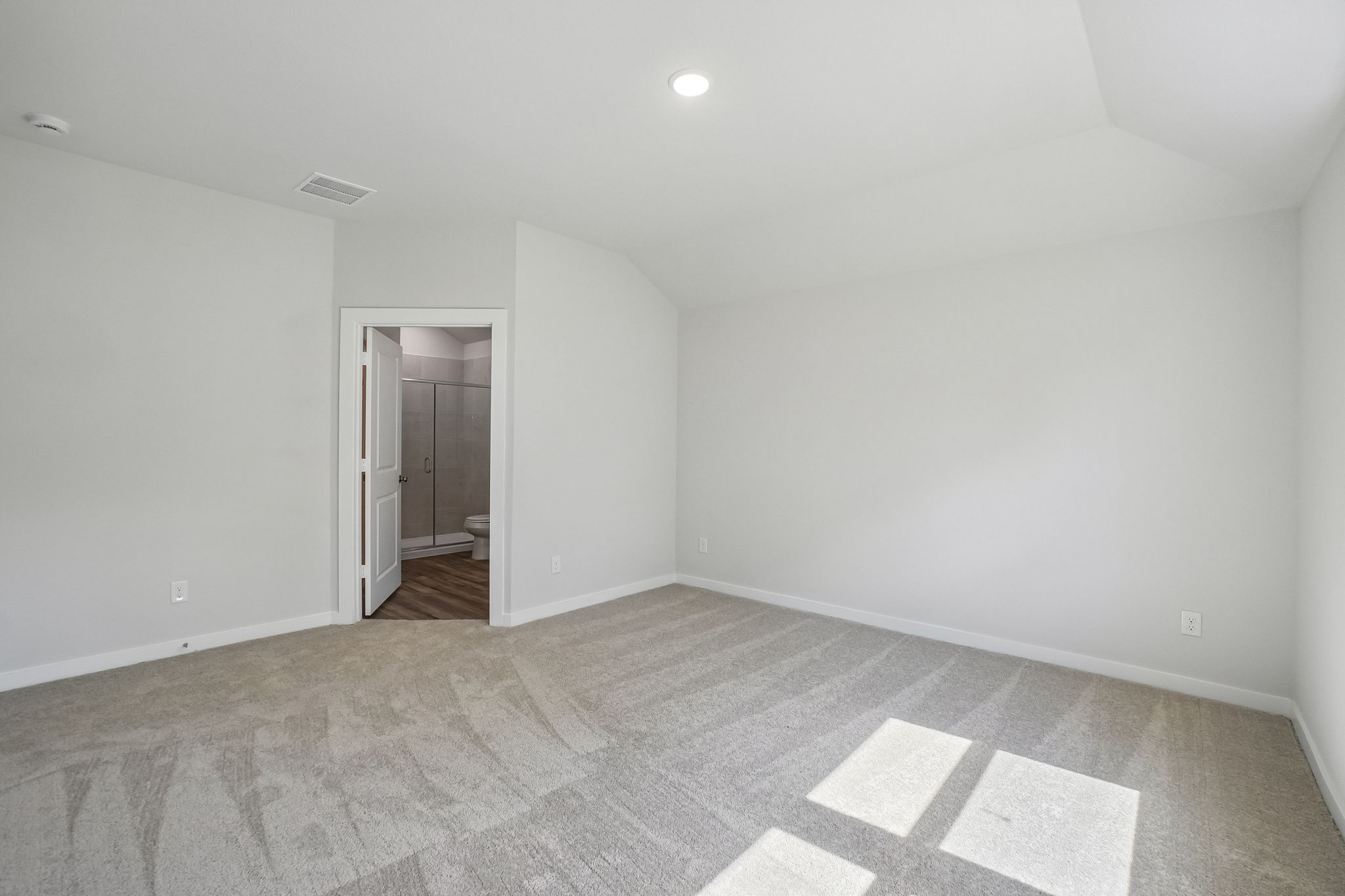 A room with a carpet and a door.
