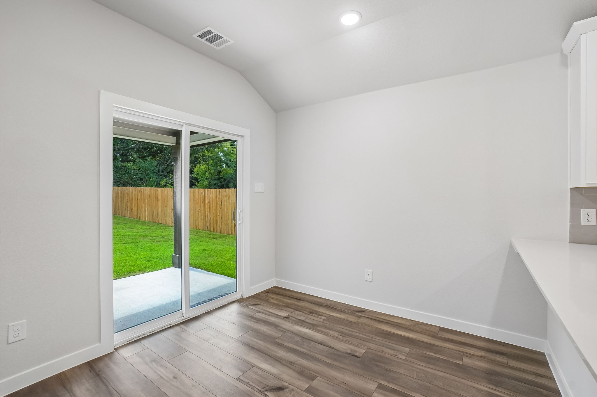 A room with a wood floor and a glass door.