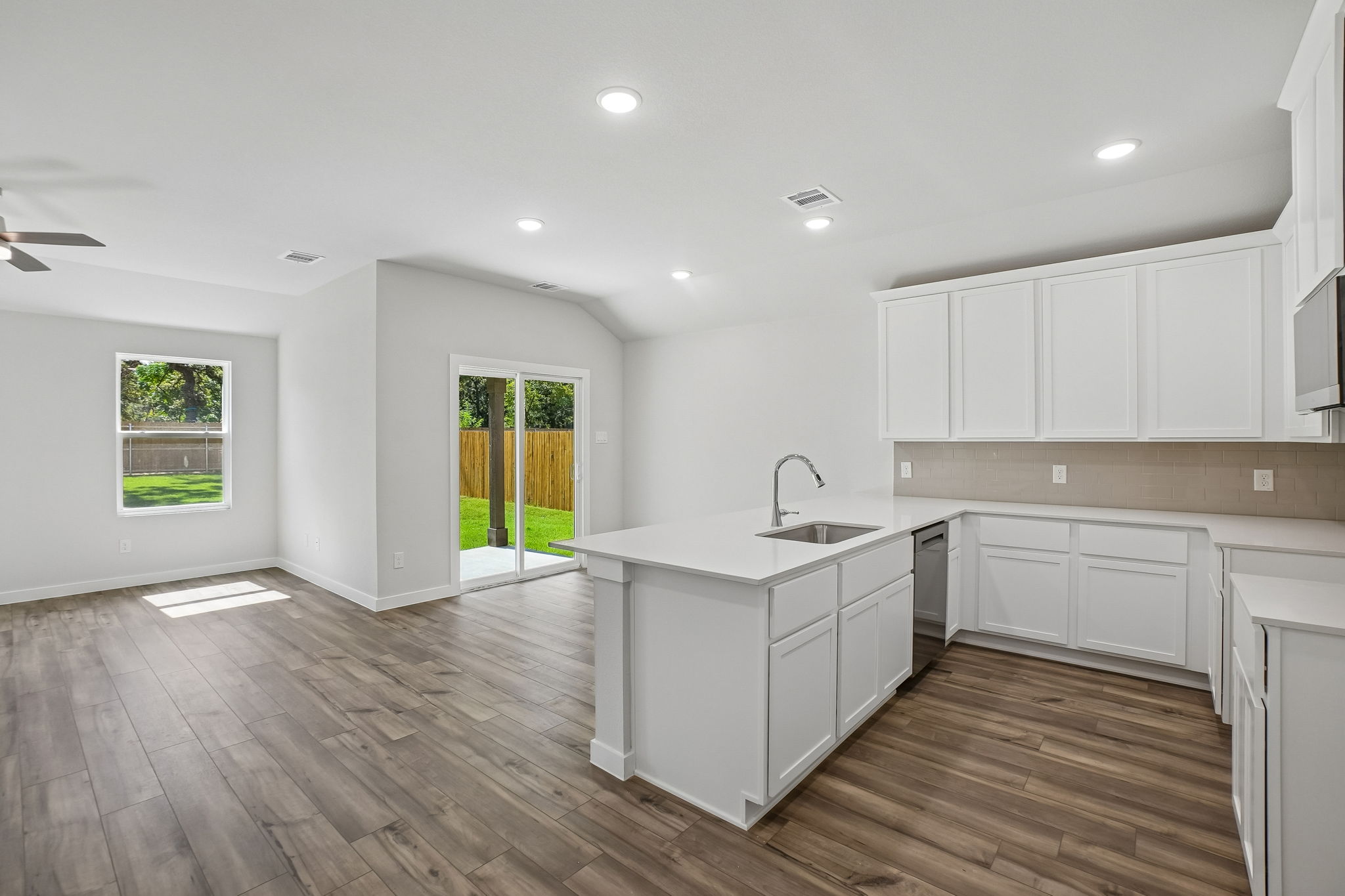 A kitchen with white cabinets.