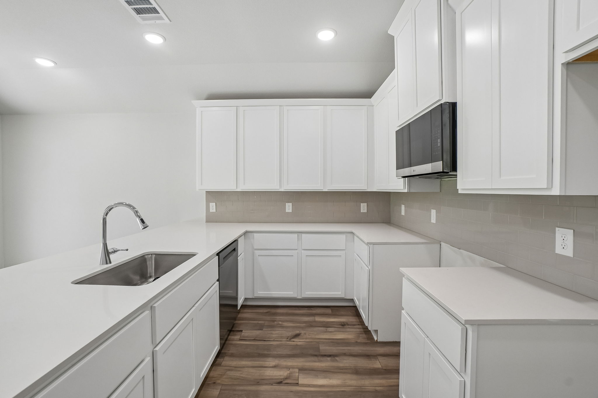 A kitchen with white cabinets.