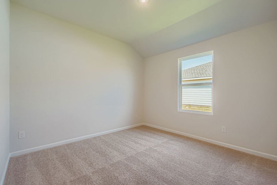 A room with a carpet and a window.