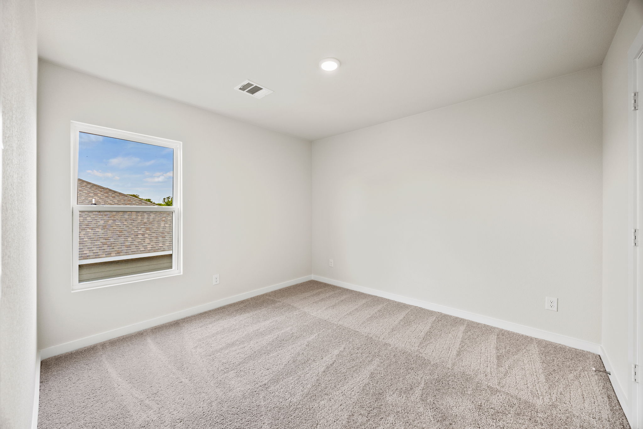 A room with a window and a rug.