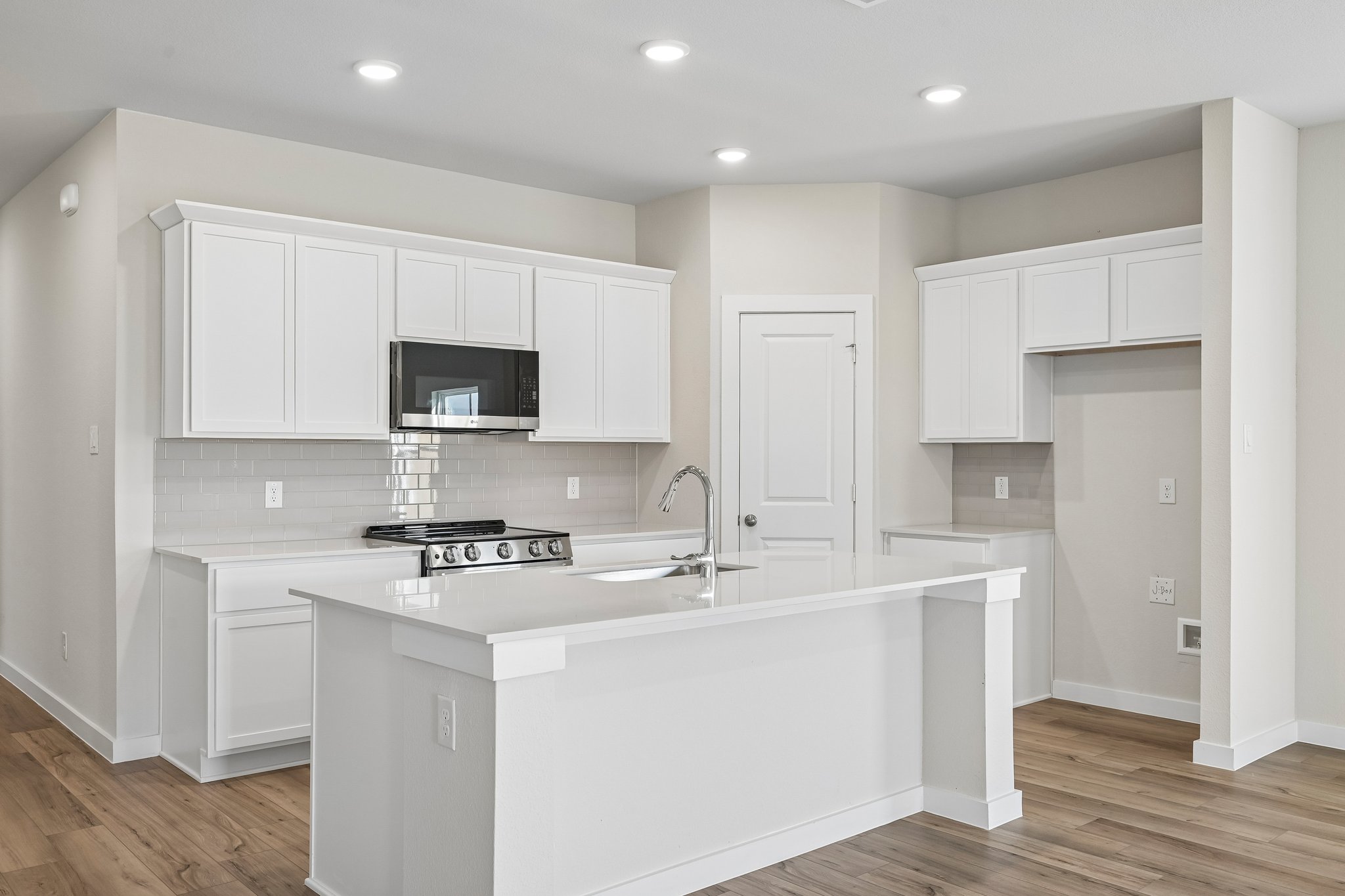 A kitchen with white cabinets.
