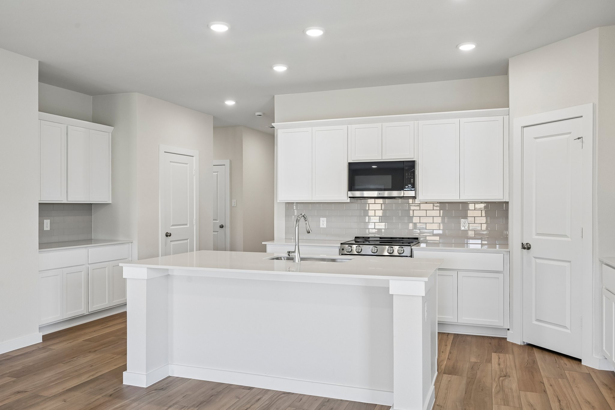 A kitchen with white cabinets.