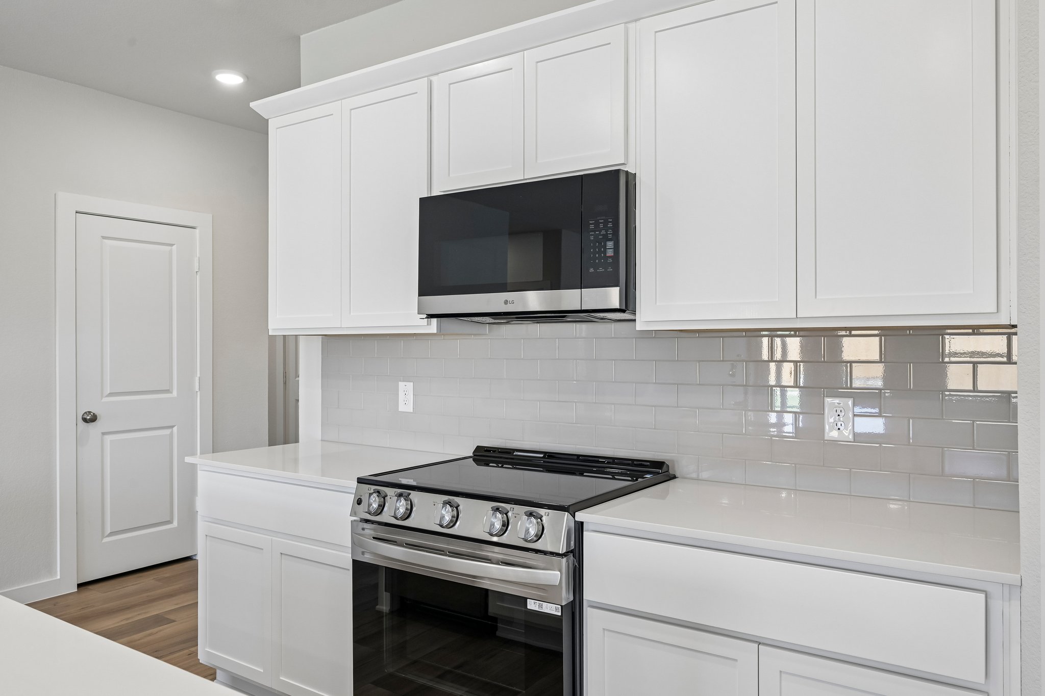 A kitchen with white cabinets.