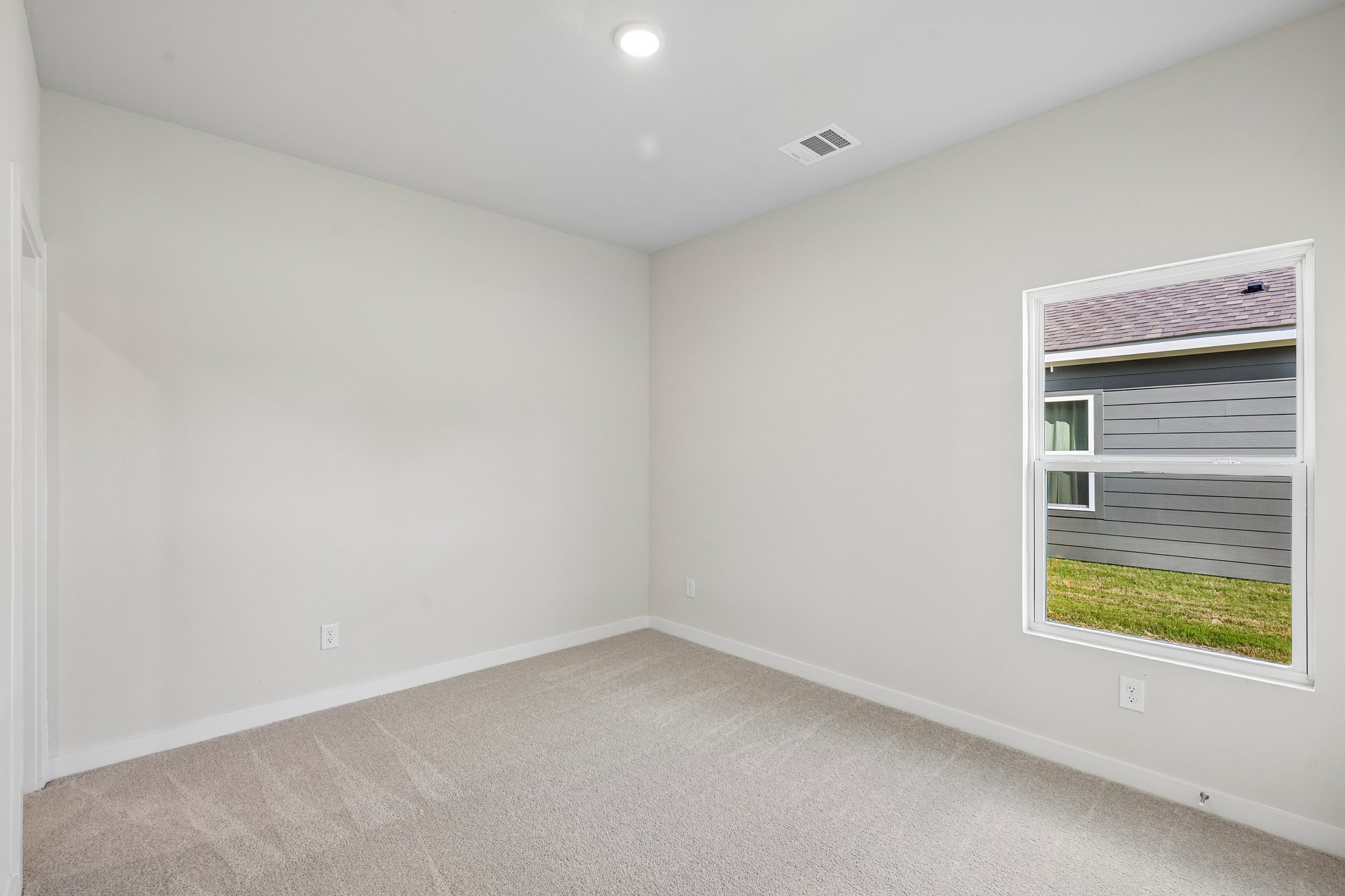 A room with a window and a carpet.