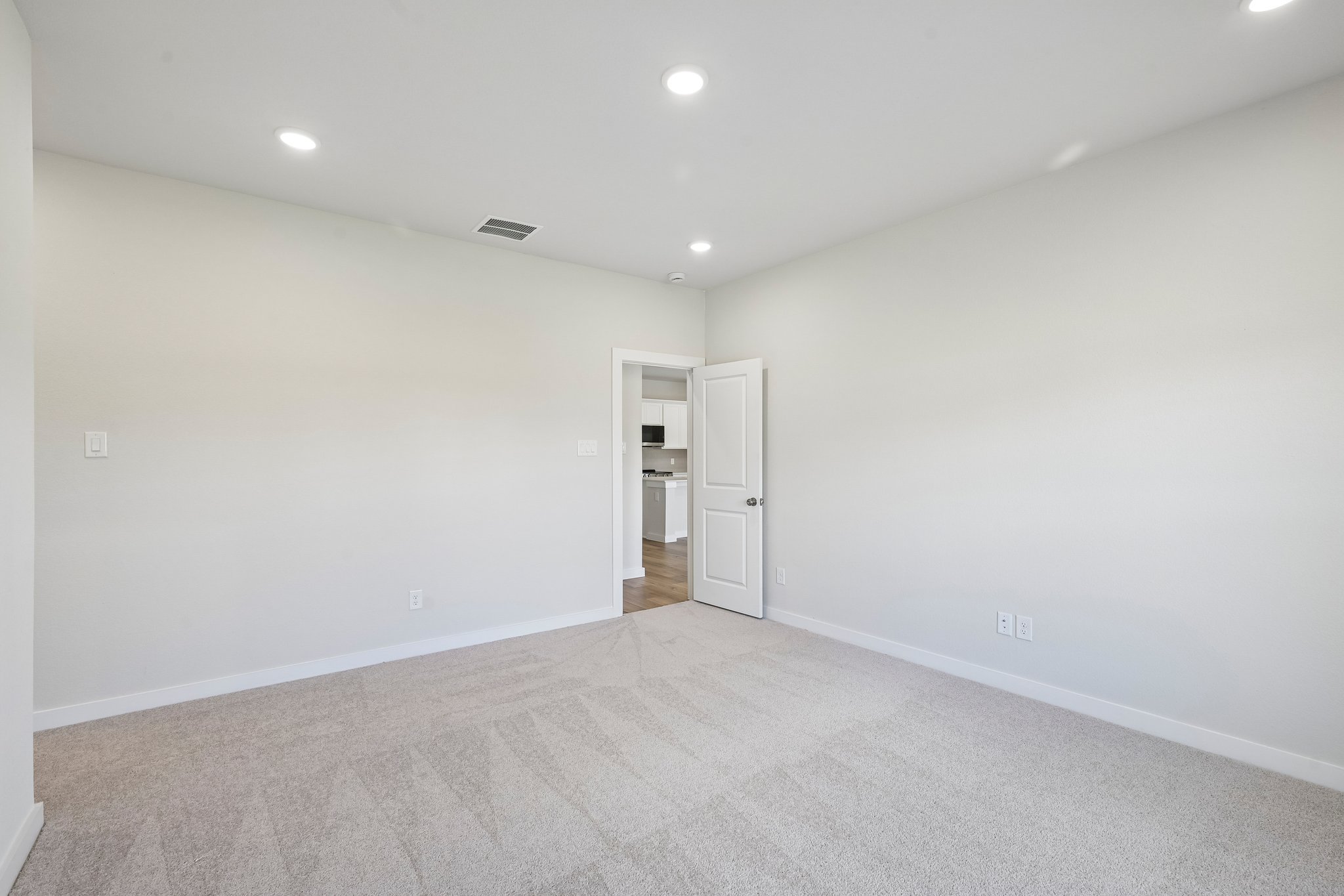 A room with a carpet and a white wall.